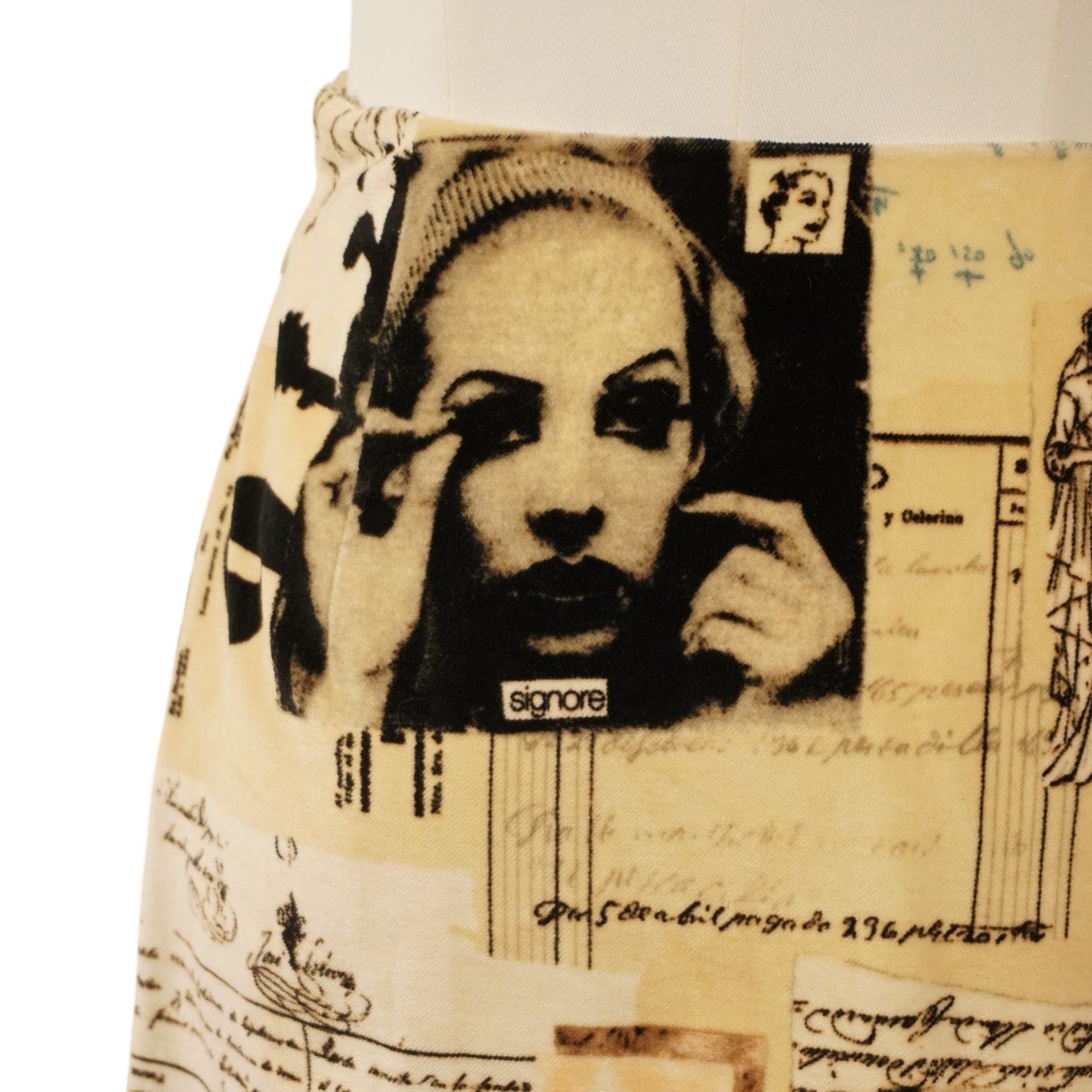 Ingrandimento della stampa sulla minigonna che mostra un volto femminile e testi in stile collage d'avanguardia.
