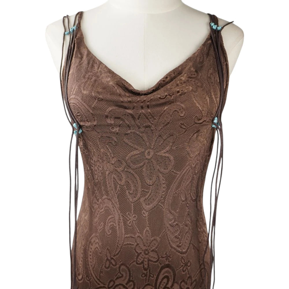  Dettaglio ravvicinato dello scollo a cappuccio drappeggiato e della trama mesh jacquard a motivi floreali.