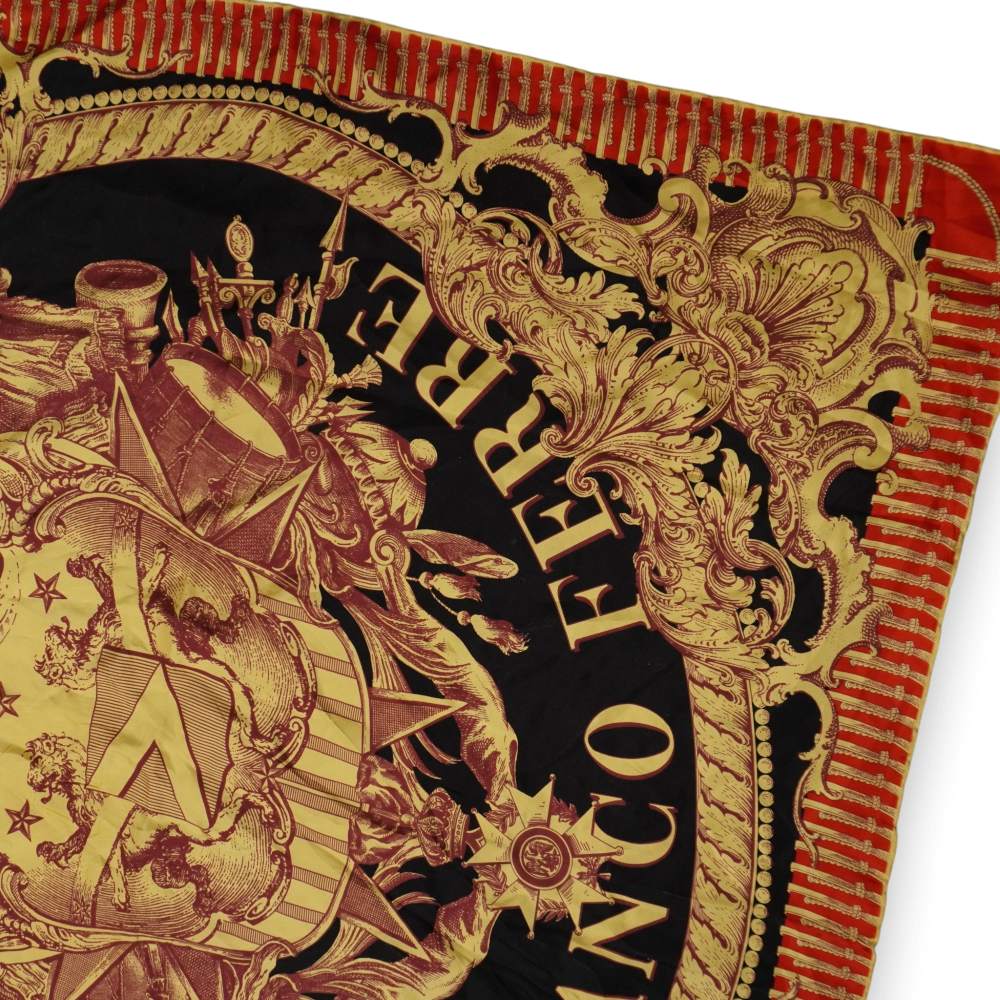 Primo piano dello stemma araldico centrale con corona reale e leoni su foulard Ferré