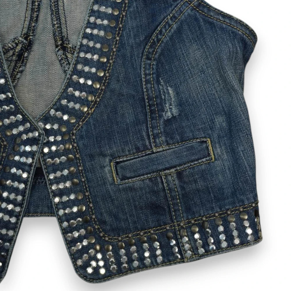 Dettaglio macro del tessuto denim anteriore sinistro con effetto consumato e finiture scucite vintage