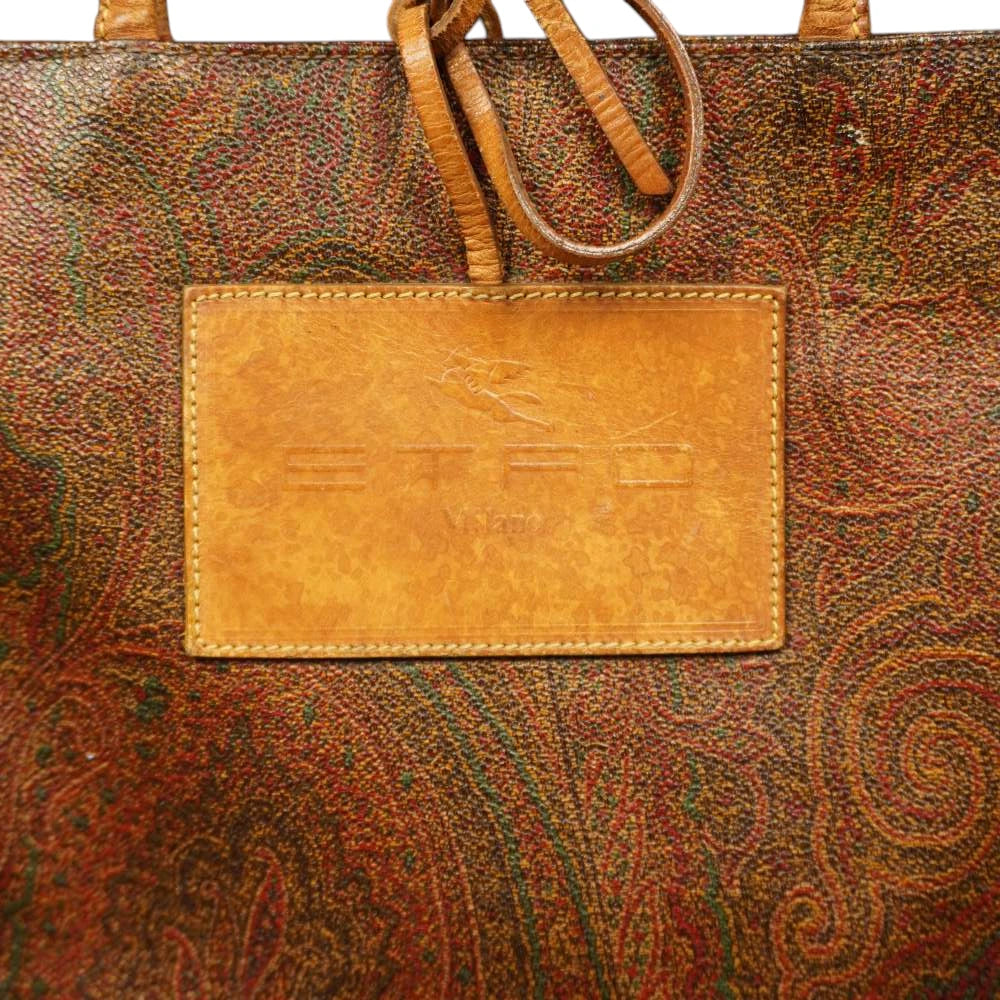  Primo piano della maxi etichetta rettangolare in pelle color cuoio con logo Etro Milano e Pegaso impresso a caldo.