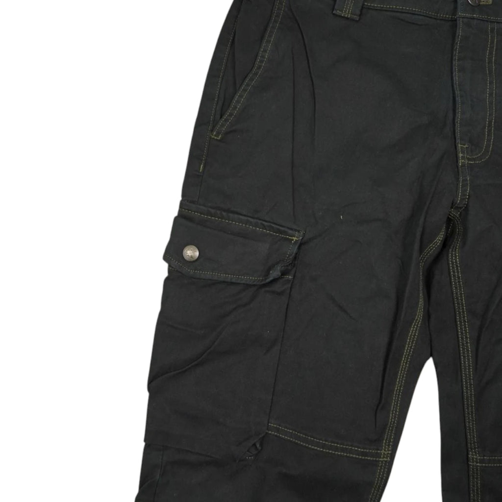 Dettaglio della tasca utility laterale con patta e cuciture a contrasto su pantalone nero