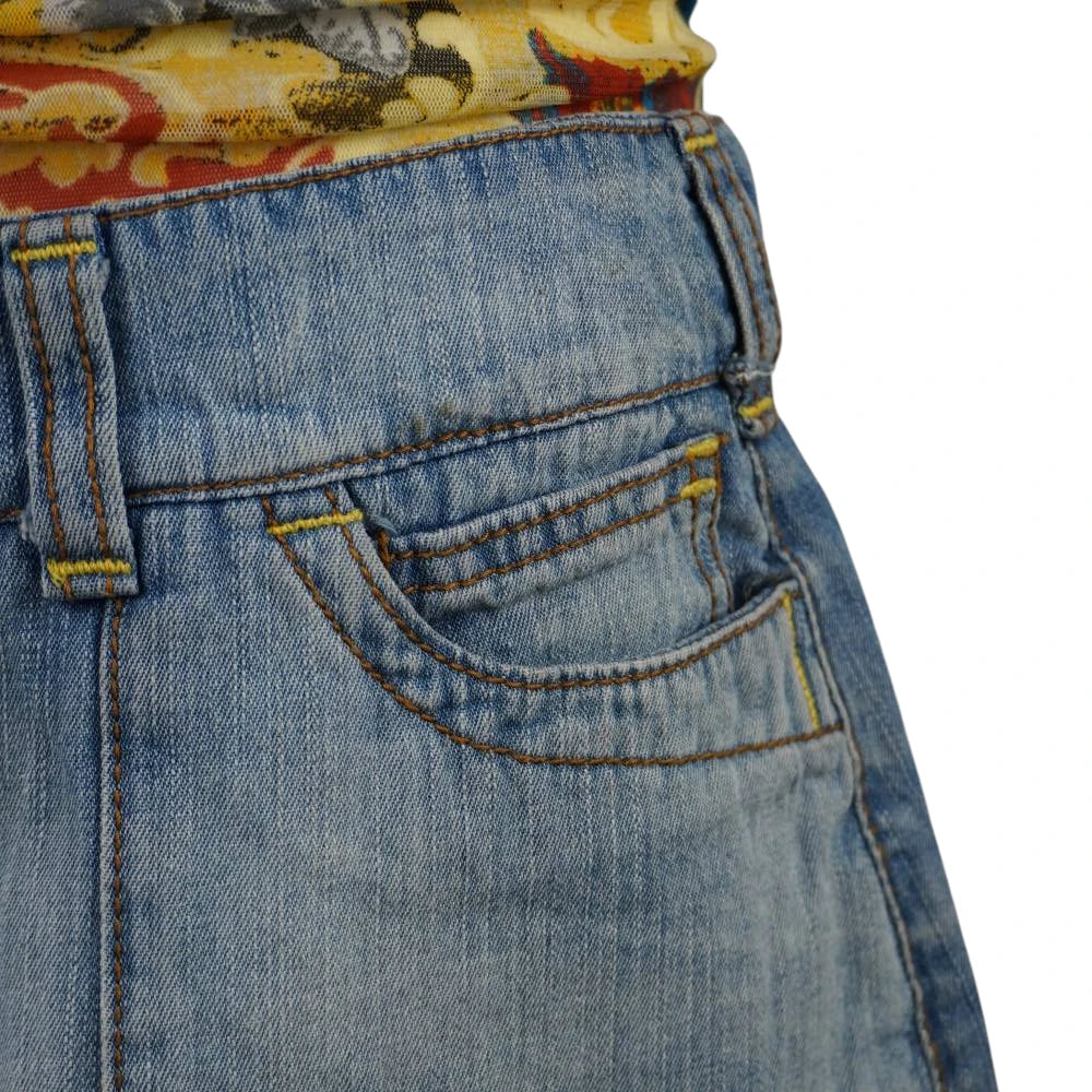 Primo piano della tasca anteriore curva con taschino coin pocket della gonna di jeans Extyn e cuciture ocra.