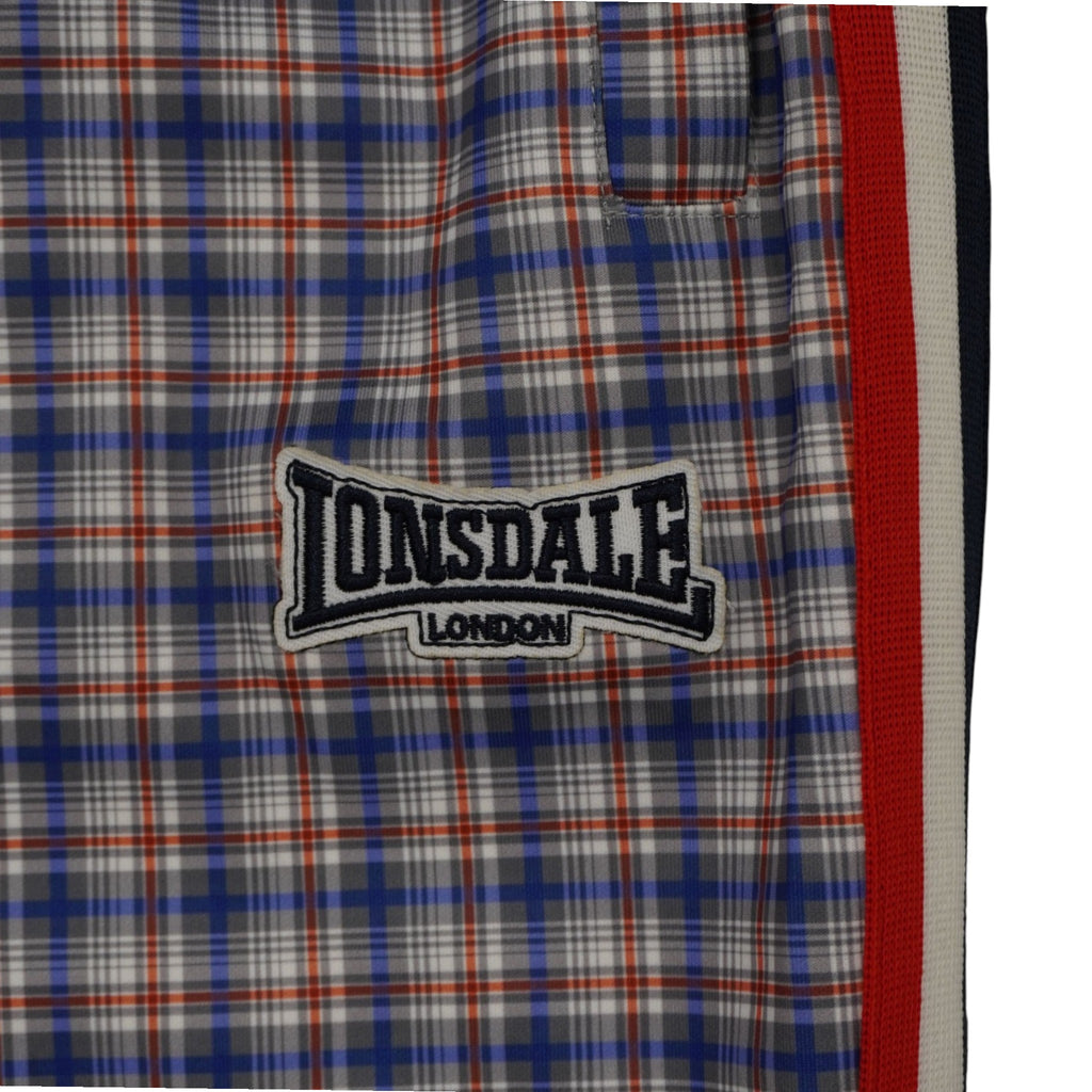 Dettaglio tasca a filetto e logo ricamato Lonsdale London su coscia pantaloni tuta a quadri tartan