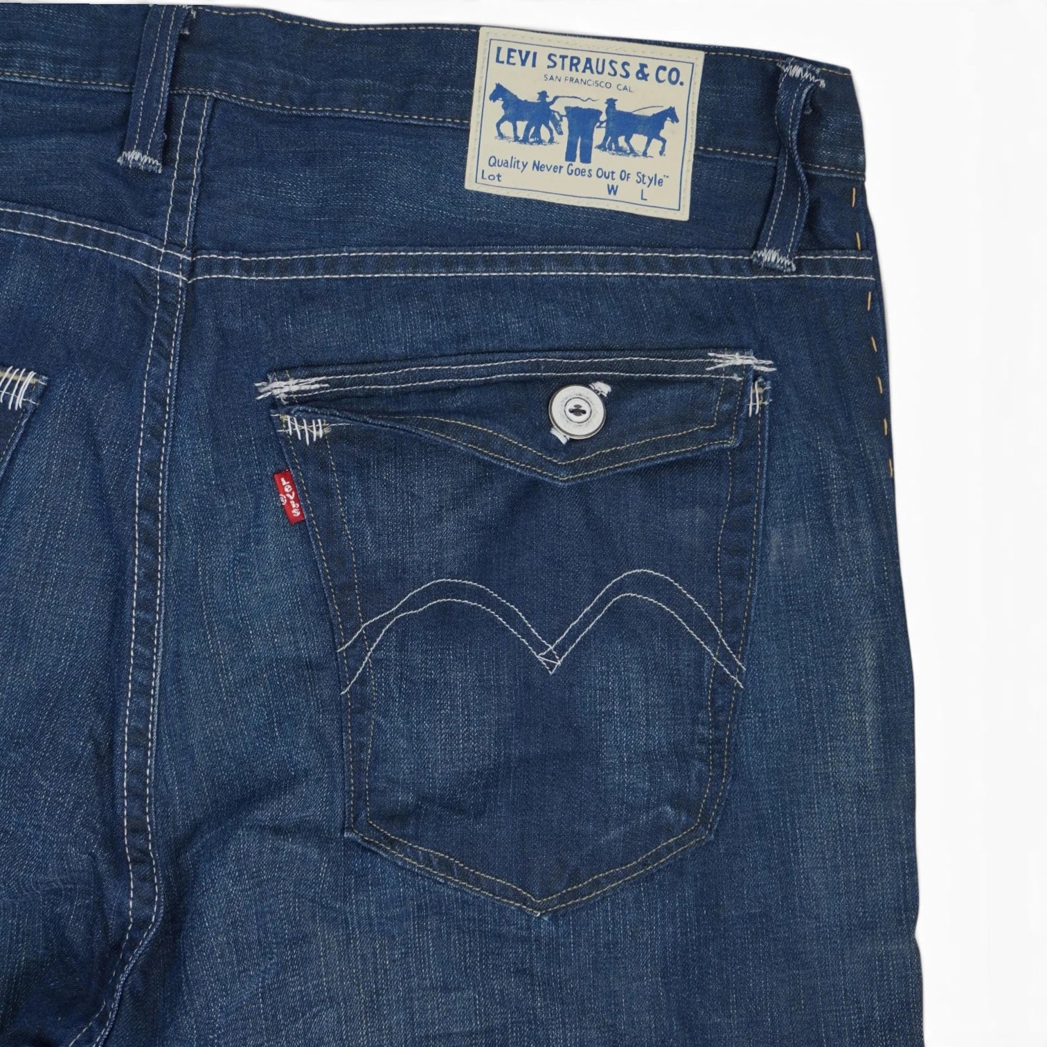 Primo piano del retro con tasca a pattina e bottone, etichetta Red Tab rossa e salpa in ecopelle bianca e blu Levi's.