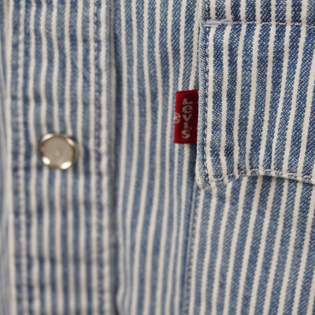 Dettaglio macro della tasca sul petto con bottone a pressione e iconica etichetta Red Tab Levi's