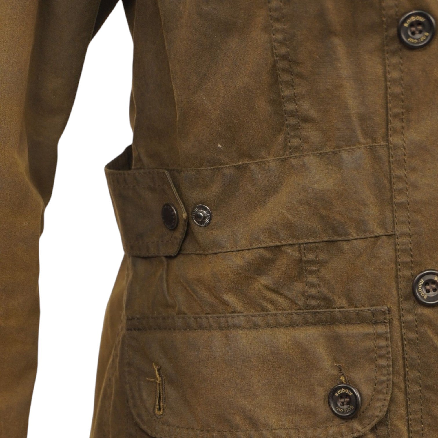 Primo piano della tasca a soffietto frontale con il ricamo discreto del logo Barbour sul cotone cerato marrone.