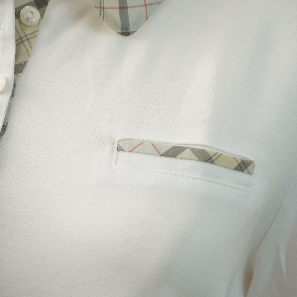 Primo piano del taschino a filo sul petto con profilo coordinato in tessuto tartan scozzese.