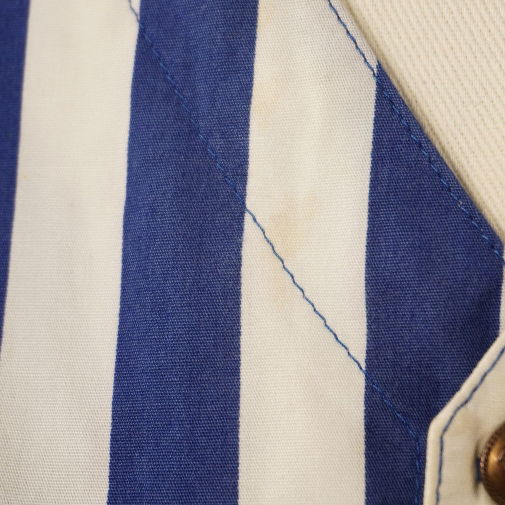 Inquadratura macro del tessuto in cotone a righe verticali blu e bianche del gilet vintage Versace