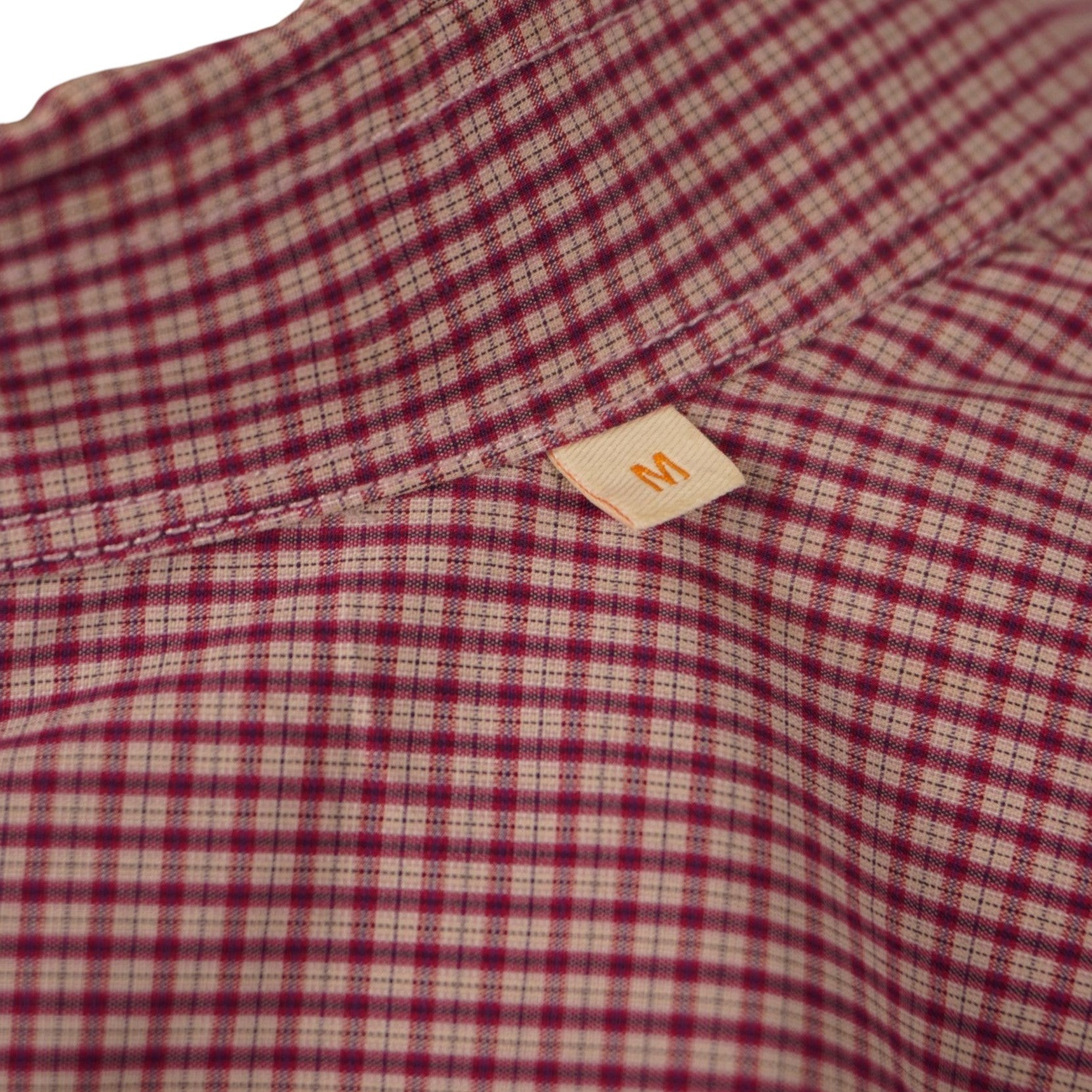 Primo piano della texture in cotone popeline a micro quadretti bordeaux e bianchi della camicia BOSS.