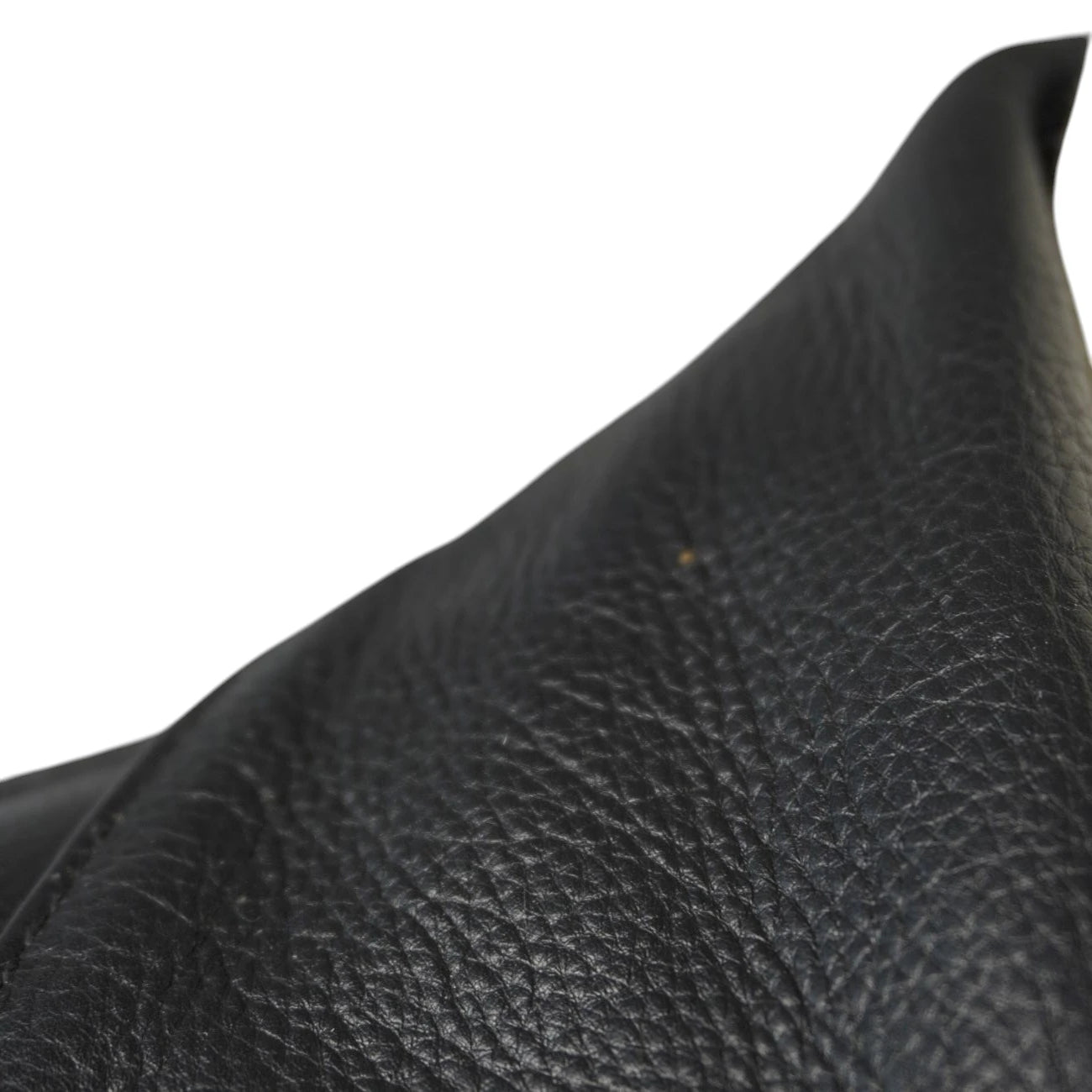 Inquadratura ravvicinata e inclinata della texture della pelle martellata nera e di una cucitura lineare.