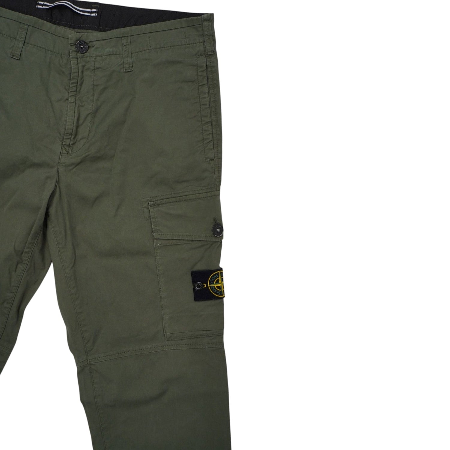 Primo piano della zona superiore del pantalone cargo verde, che mostra il bottone in vita e la patta frontale.