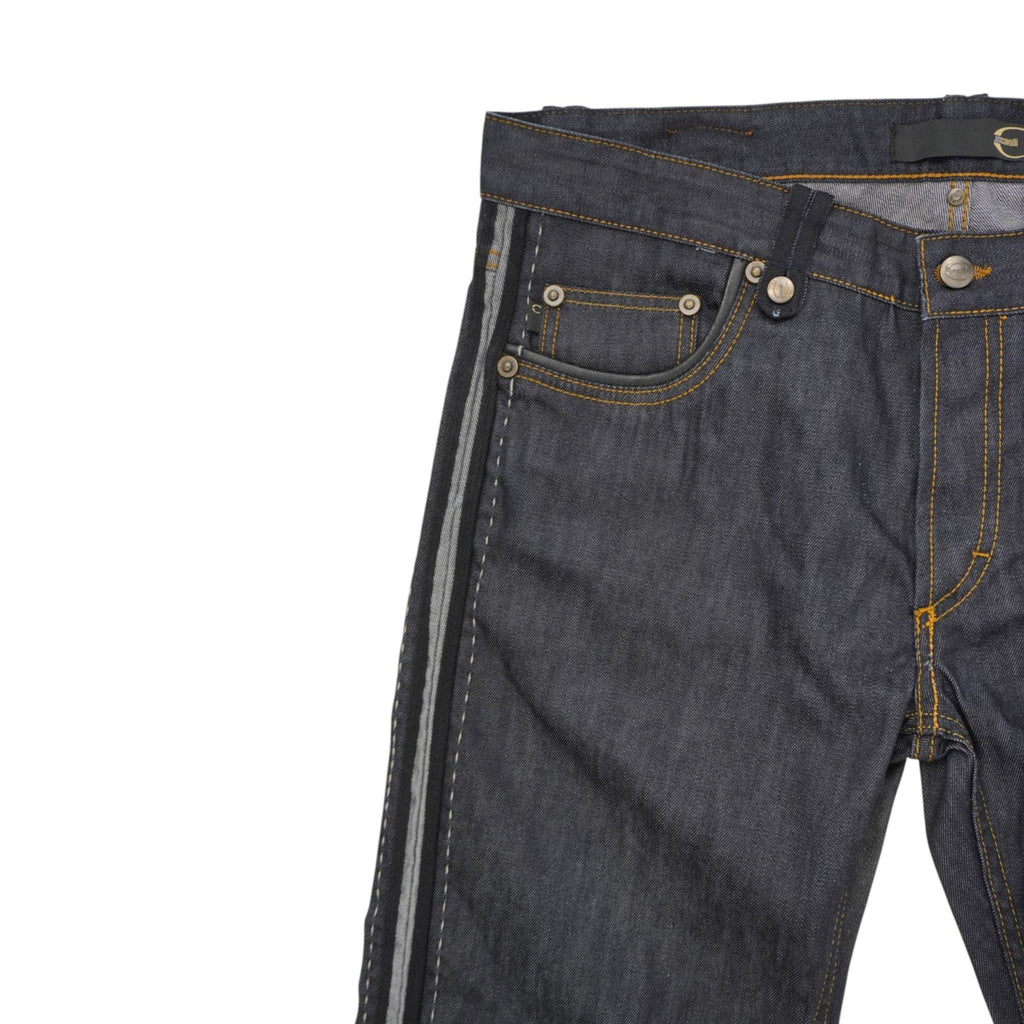 Vista frontale della parte superiore dei jeans focalizzata sul girovita, sul taschino per le monete e sulle cuciture color tabacco.