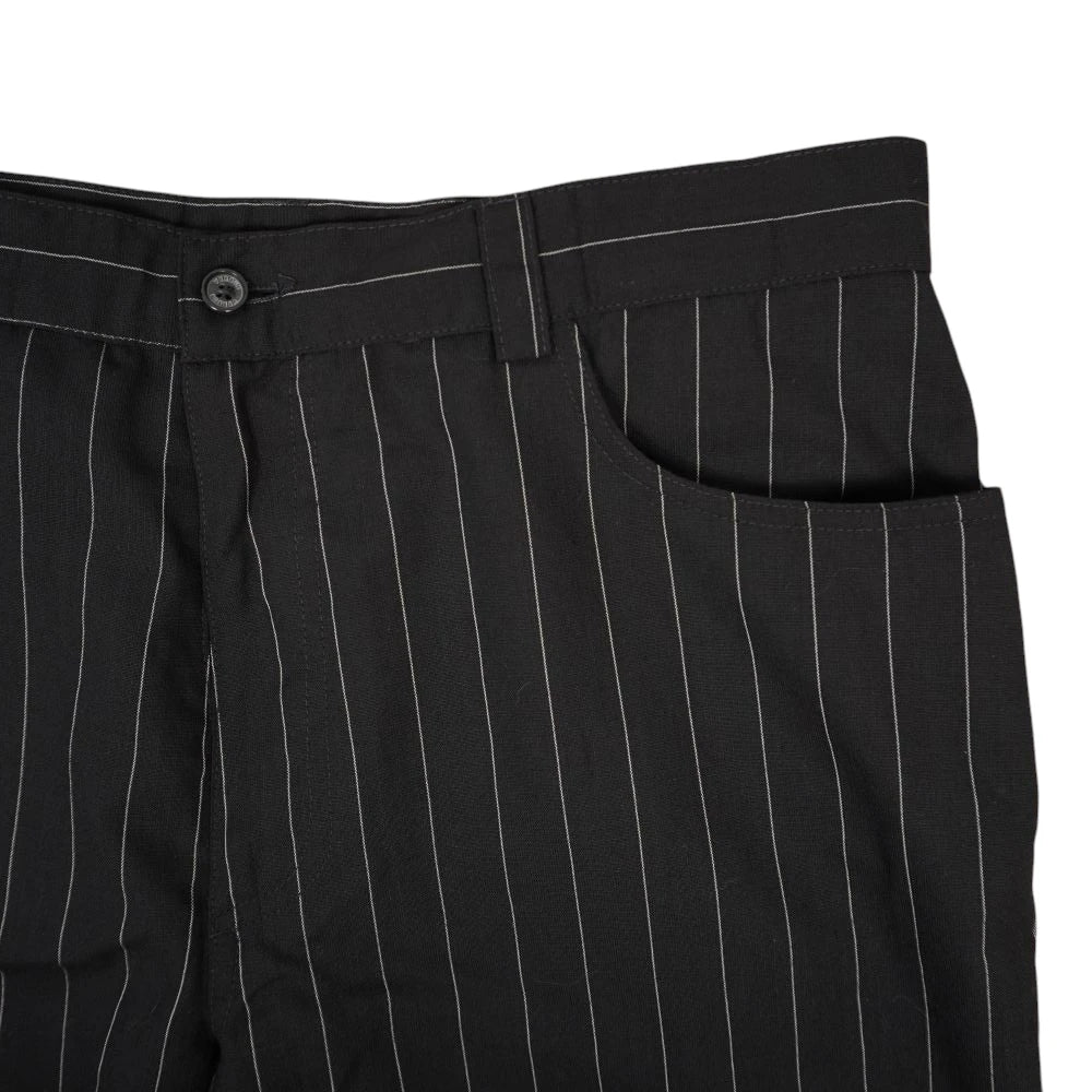 Dettaglio ravvicinato della parte superiore frontale dei pantaloni Versus Versace con tasca curva stile jeans e passanti.