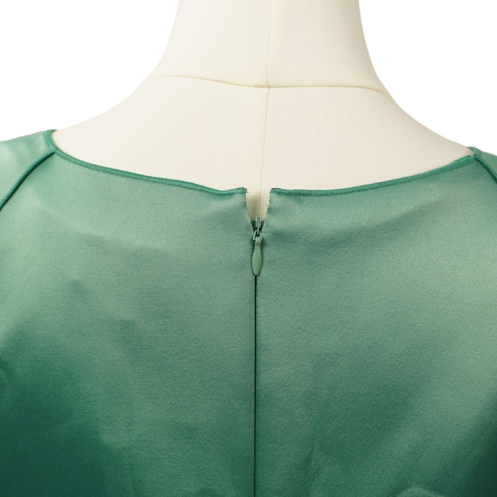 Primo piano della chiusura lampo invisibile sul retro dello scollo dell'abito verde.