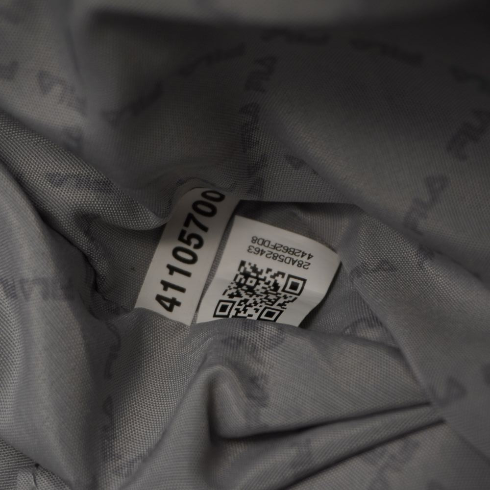 Dettaglio dell'etichetta di autenticità cucita all'interno della fodera grigia della borsa FILA con codice QR e seriale numerico di controllo.