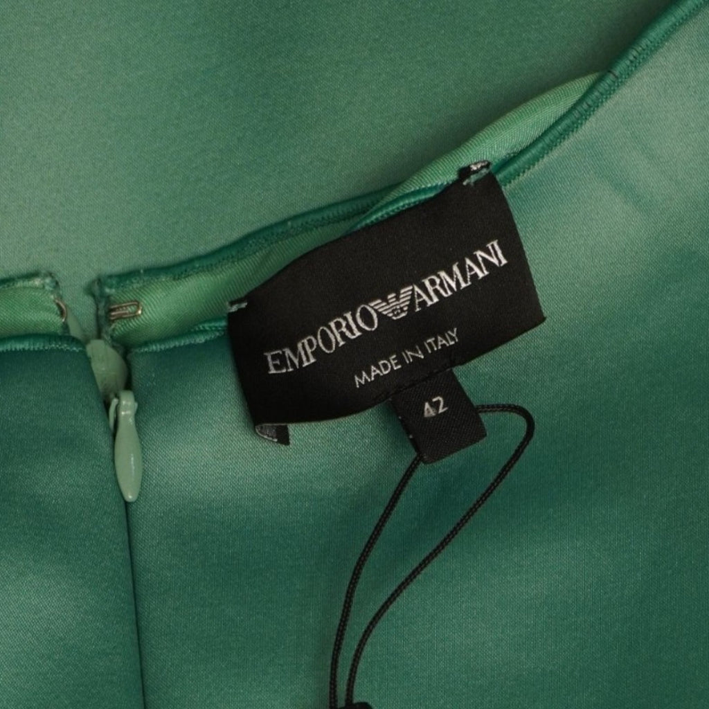 Primo piano dell'etichetta interna nera rettangolare con il logo Emporio Armani cucita vicino alla cerniera.