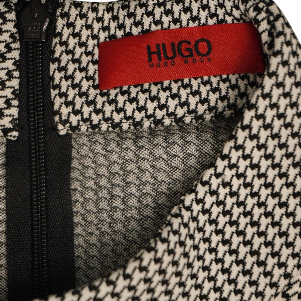 Primo piano dell'etichetta interna rettangolare di colore rosso con il logo HUGO ricamato in nero.