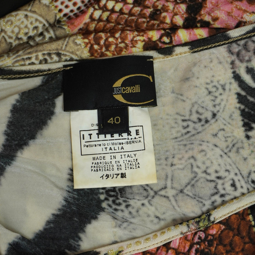 Primo piano dell'etichetta interna rettangolare nera con il logo Just Cavalli e il relativo cartellino di produzione cuciti sullo scollo.
