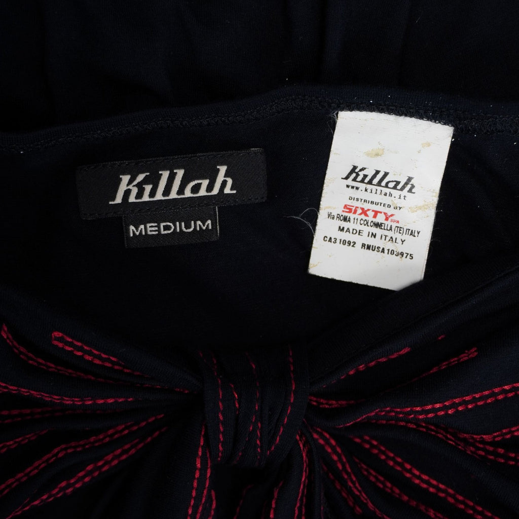 Dettaglio dell'etichetta interna nera con logo Killah scritto in bianco vicino alla scollatura, affiancata da un cartellino di taglia chiaro.