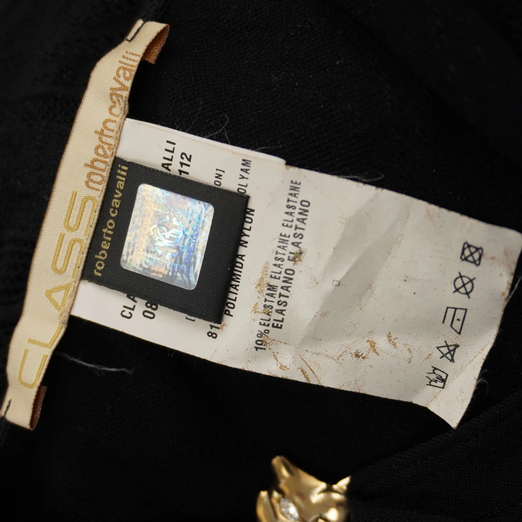 Etichetta in tessuto Class Roberto Cavalli accanto al talloncino con ologramma argentato di autenticità.