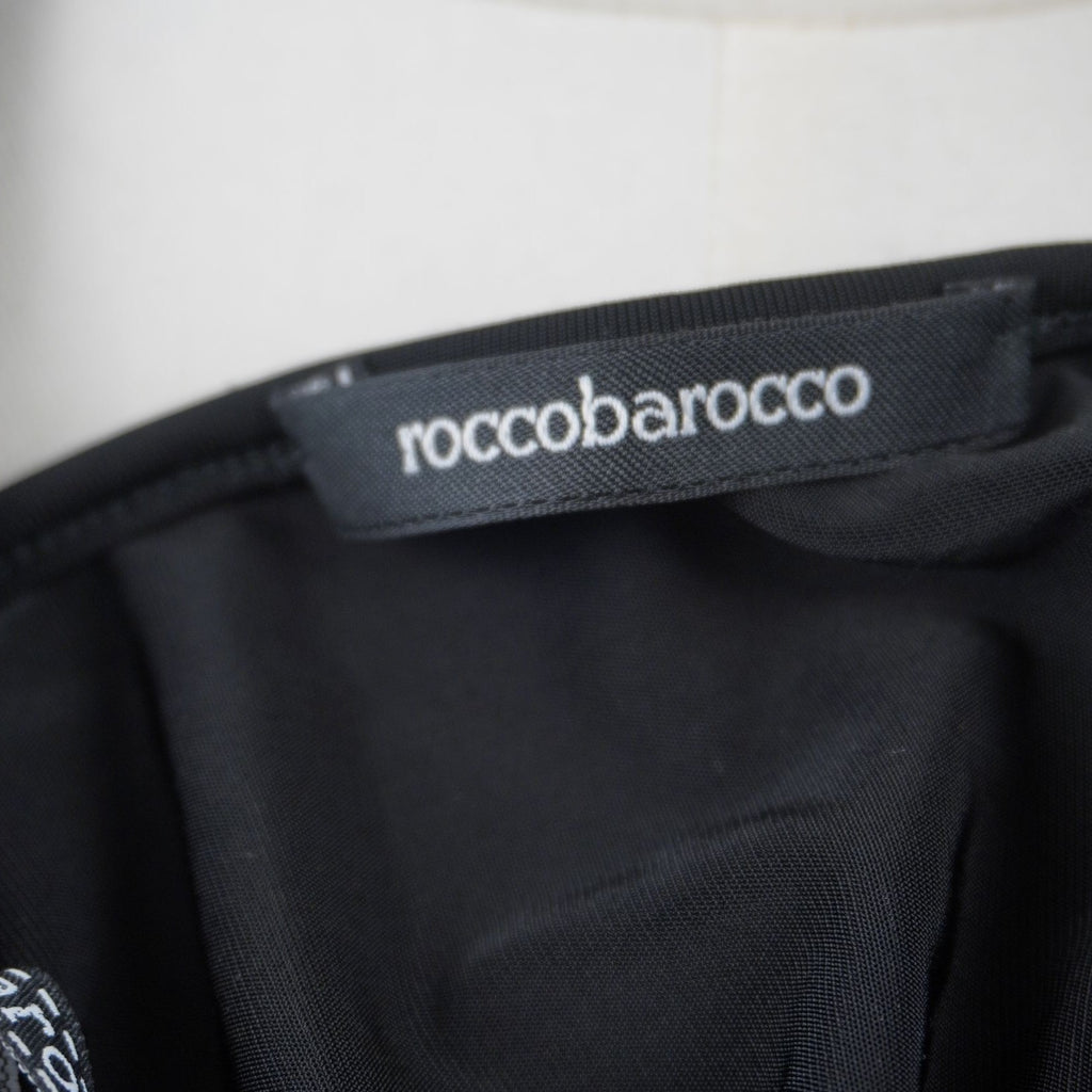 Dettaglio dell'etichetta rettangolare nera con il marchio Roccobarocco cucita sulla finitura interna del bordo.