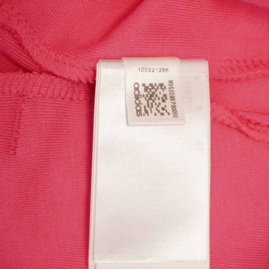Primo piano del cartellino interno bianco lucido con il QR code di tracciabilità del prodotto Adidas.