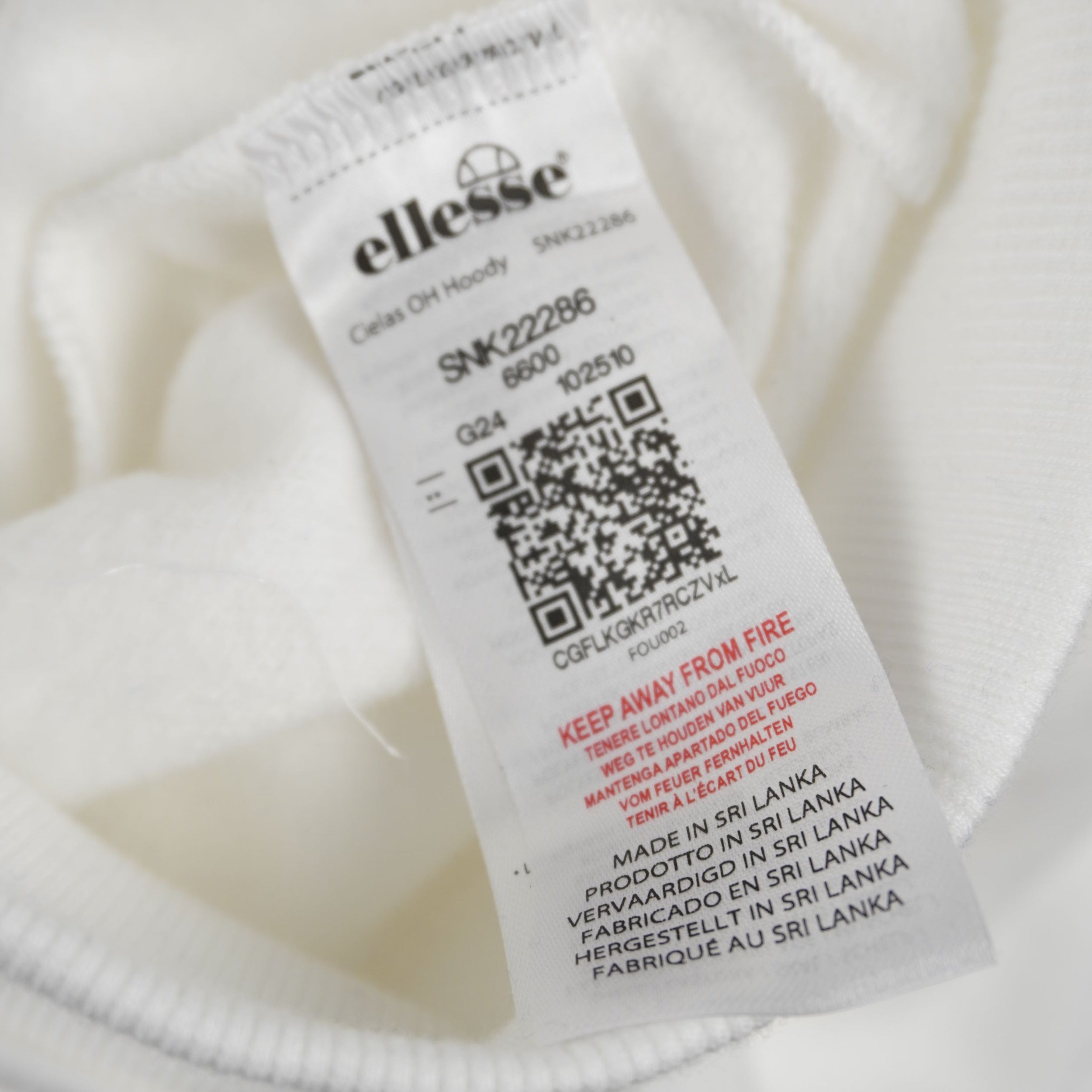 Etichetta bianca interna della felpa ellesse dotata di codice QR per la verifica di autenticità del capo.