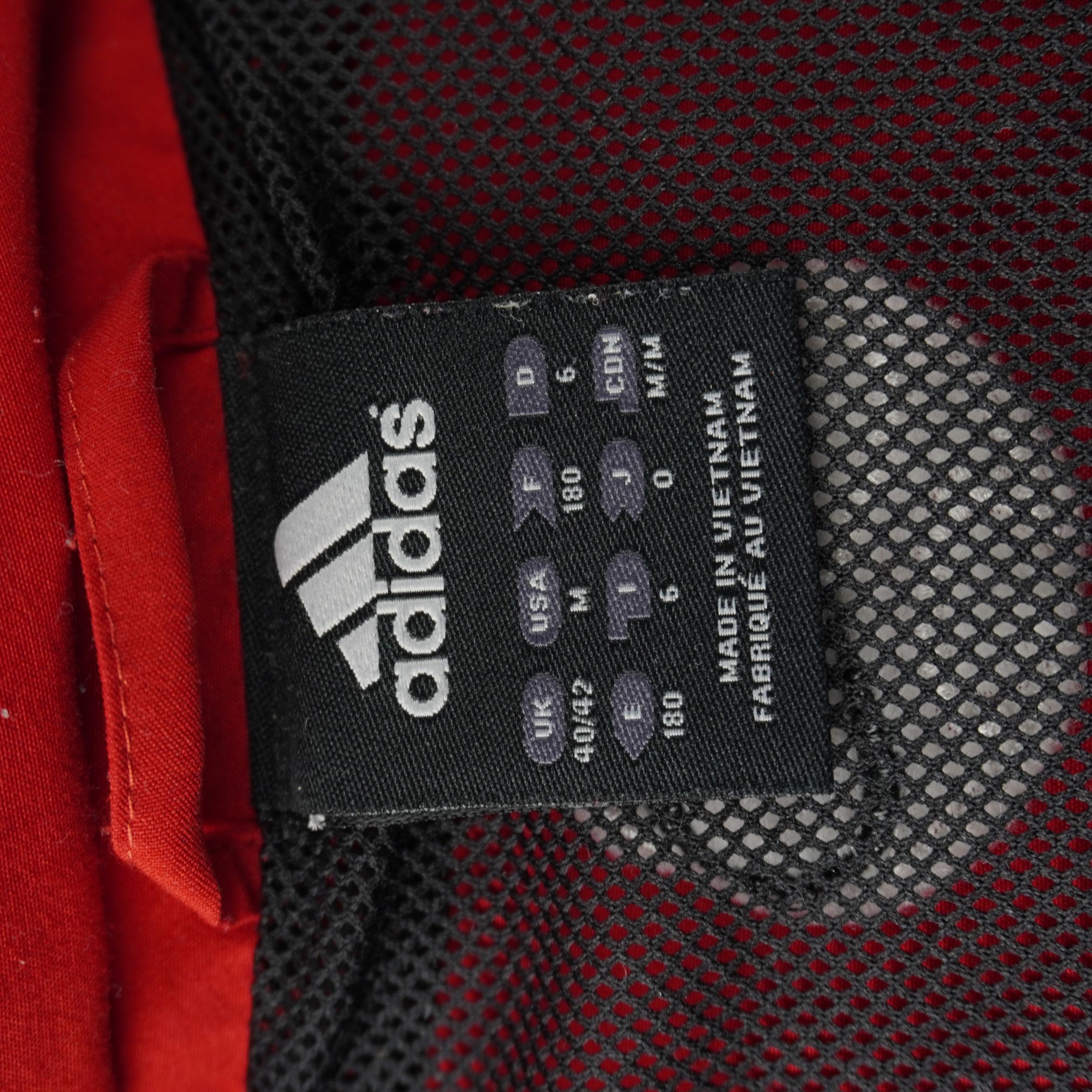 Tag nero interno al colletto con logo adidas e griglia delle taglie internazionali che indica la misura I 6.