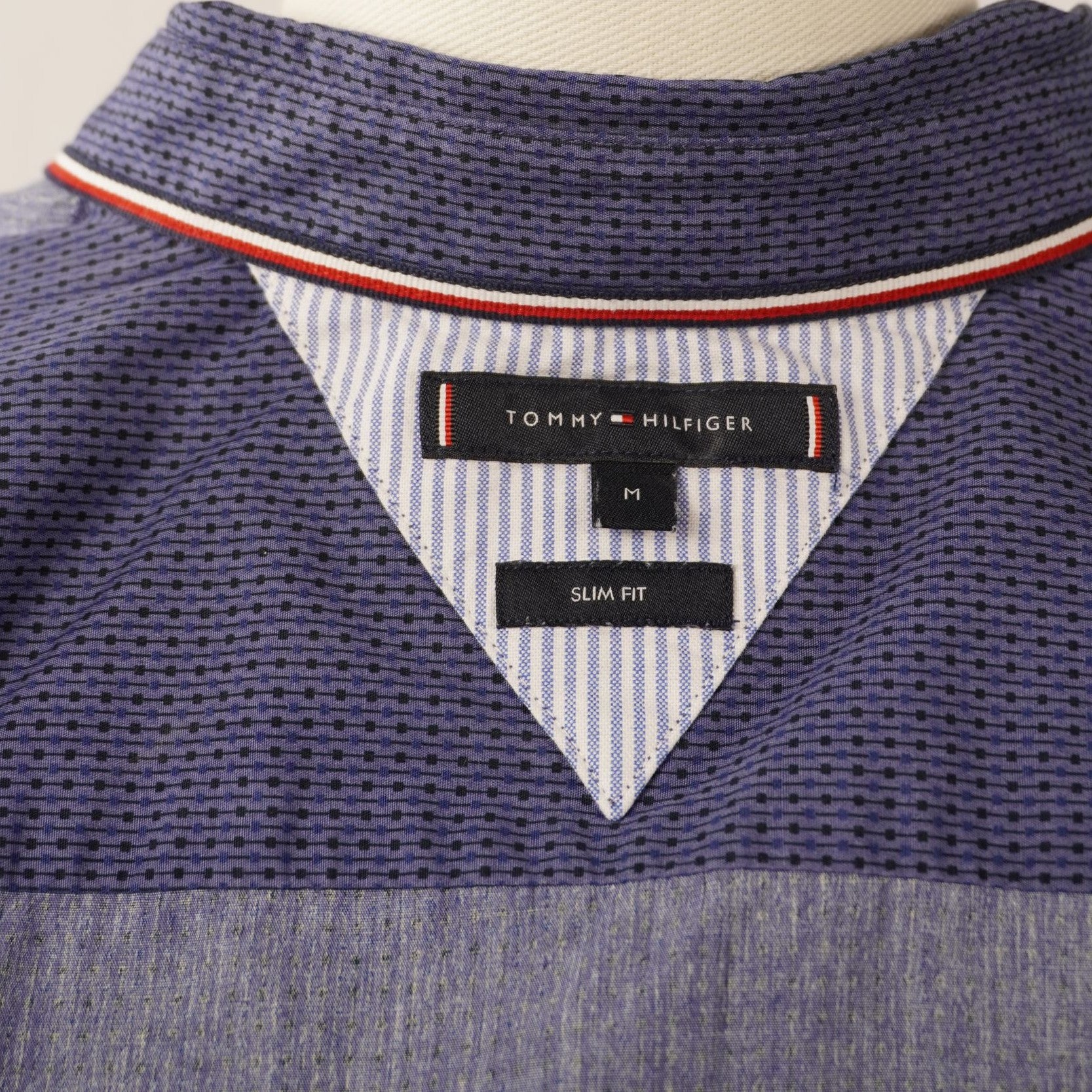 Dettaglio etichetta Tommy Hilfiger sul colletto interno con profilo tricolore iconico del brand