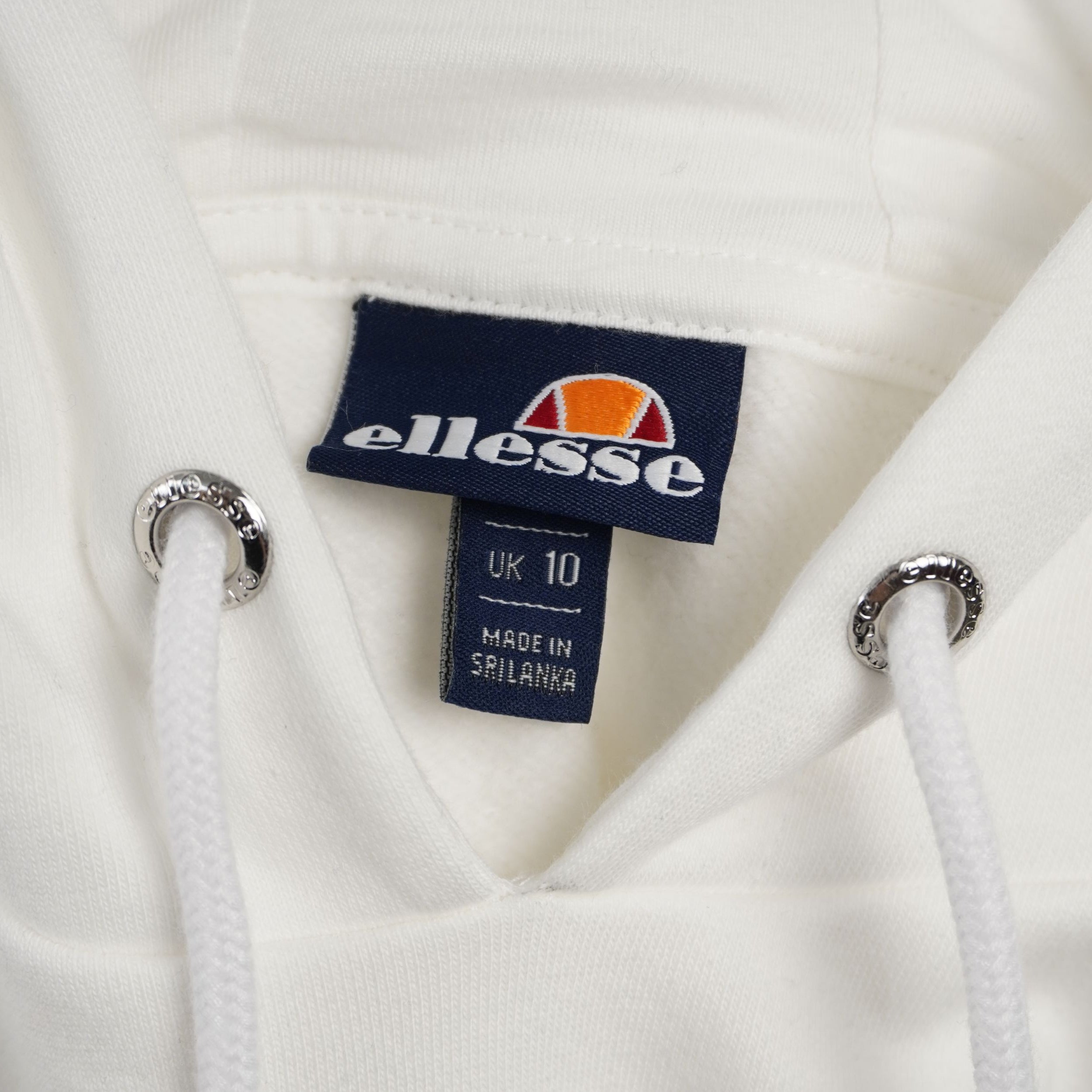 Etichetta interna in tessuto blu navy cucita sul collo della felpa ellesse con il logo del brand.