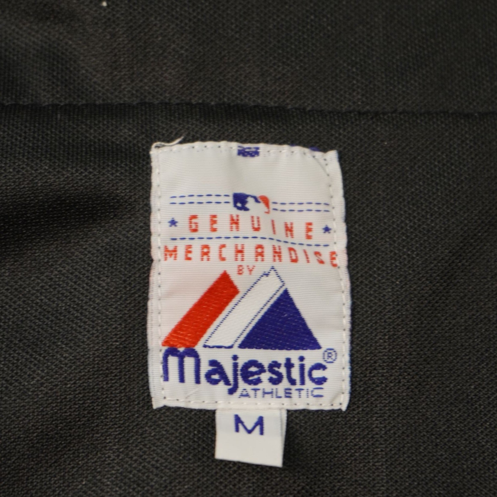 Primo piano dell'etichetta del colletto Majestic Official Merchandise che indica la taglia M.