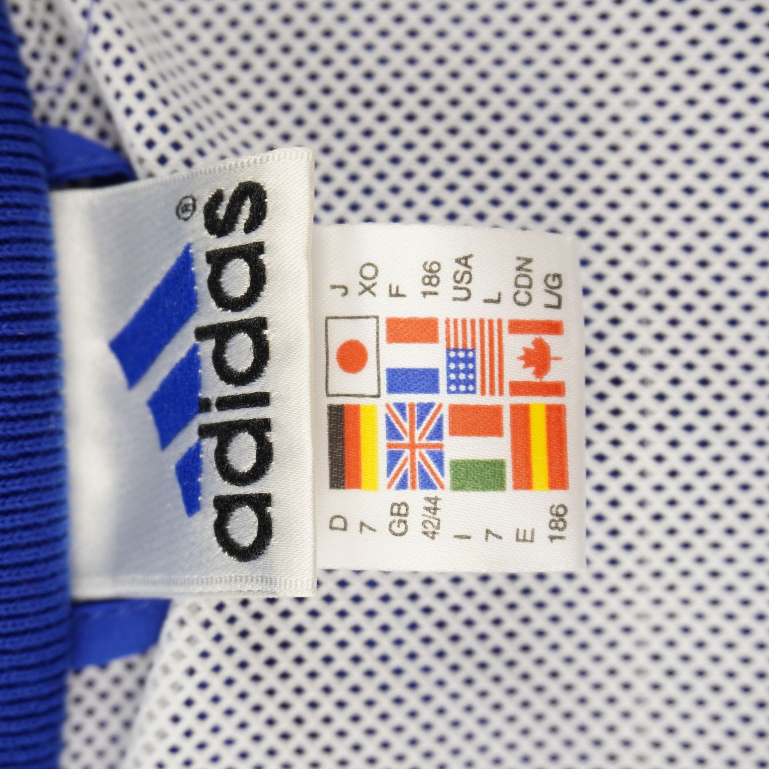 Primo piano dell'etichetta d'archivio adidas applicata sulla fodera interna in mesh bianca traspirante.