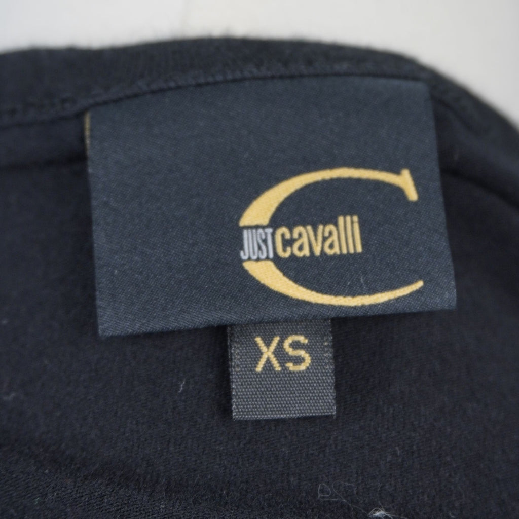 Etichetta del colletto in tessuto jacquard nero con logo dorato Just Cavalli e tag della taglia XS.