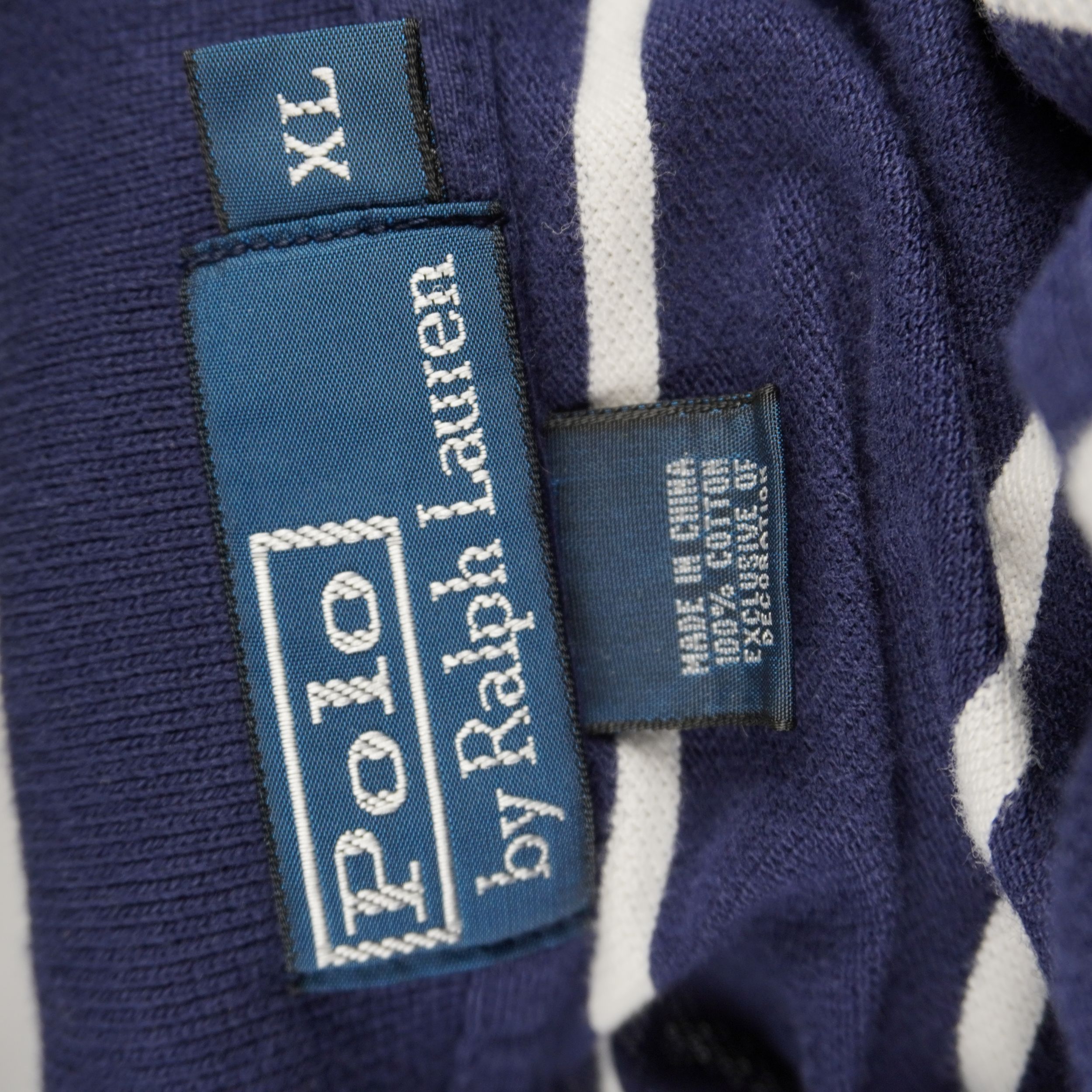 Primo piano dell'etichetta blu nel colletto Polo by Ralph Lauren con indicazione della taglia XL e del modello.
