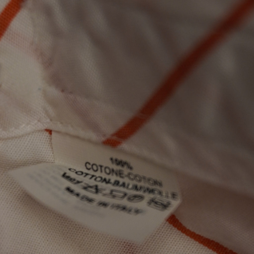 Dettaglio ravvicinato dell'etichetta interna di composizione della camicia Etro che certifica il tessuto 100% cotone e la manifattura Made in Italy con i relativi simboli di lavaggio.
