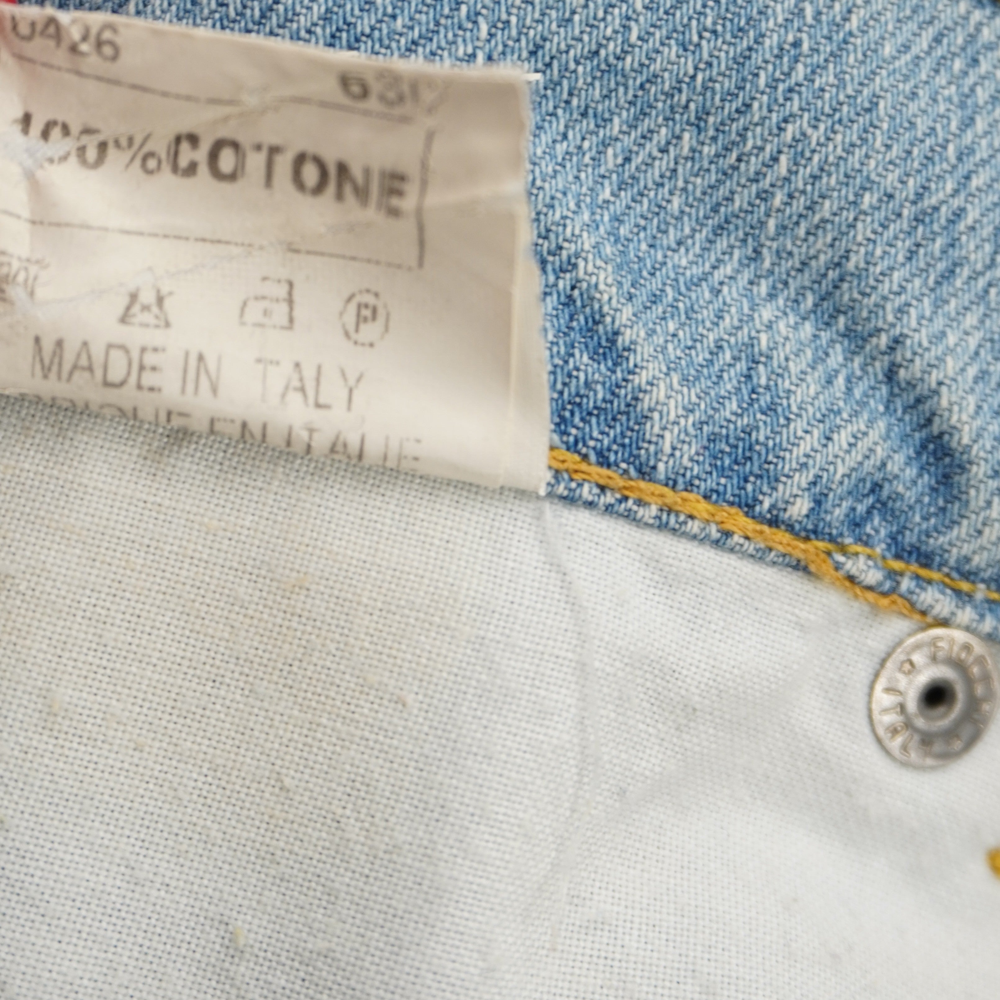 Dettaglio dell'etichetta interna che certifica il tessuto in 100% cotone e la manifattura Made in Italy.