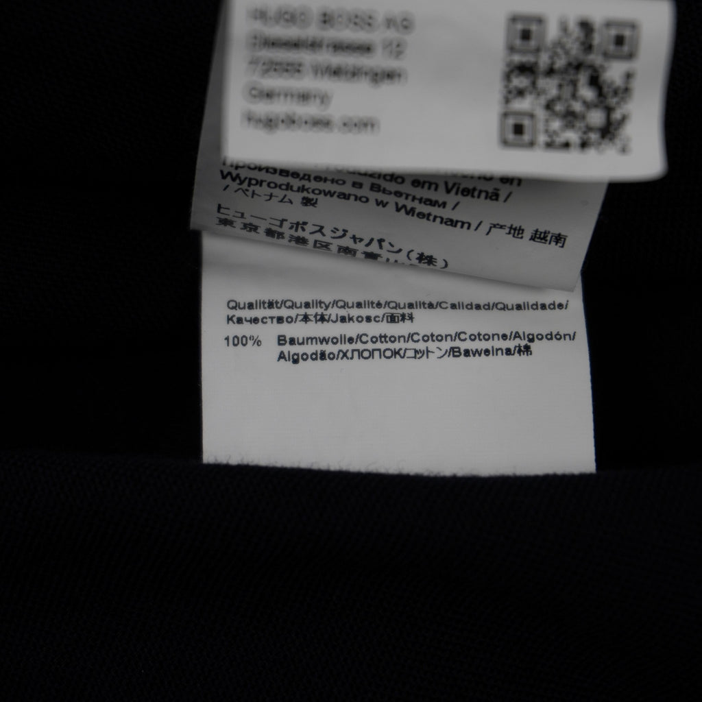 Etichetta bianca interna della camicia HUGO con i codici identificativi di produzione della linea.