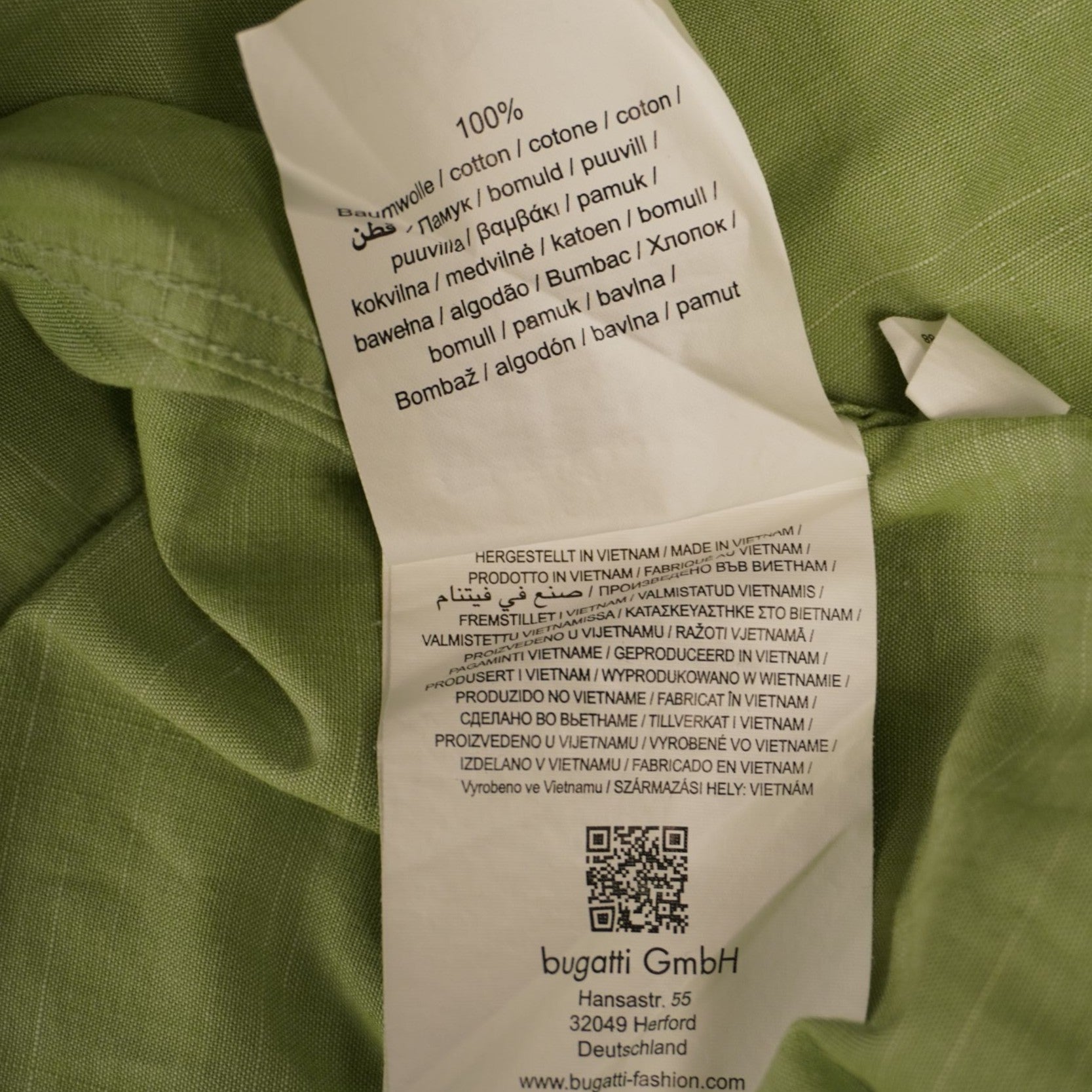 Vista dell'etichetta bianca interna con le specifiche dei materiali in misto lino e il QR code di tracciabilità.