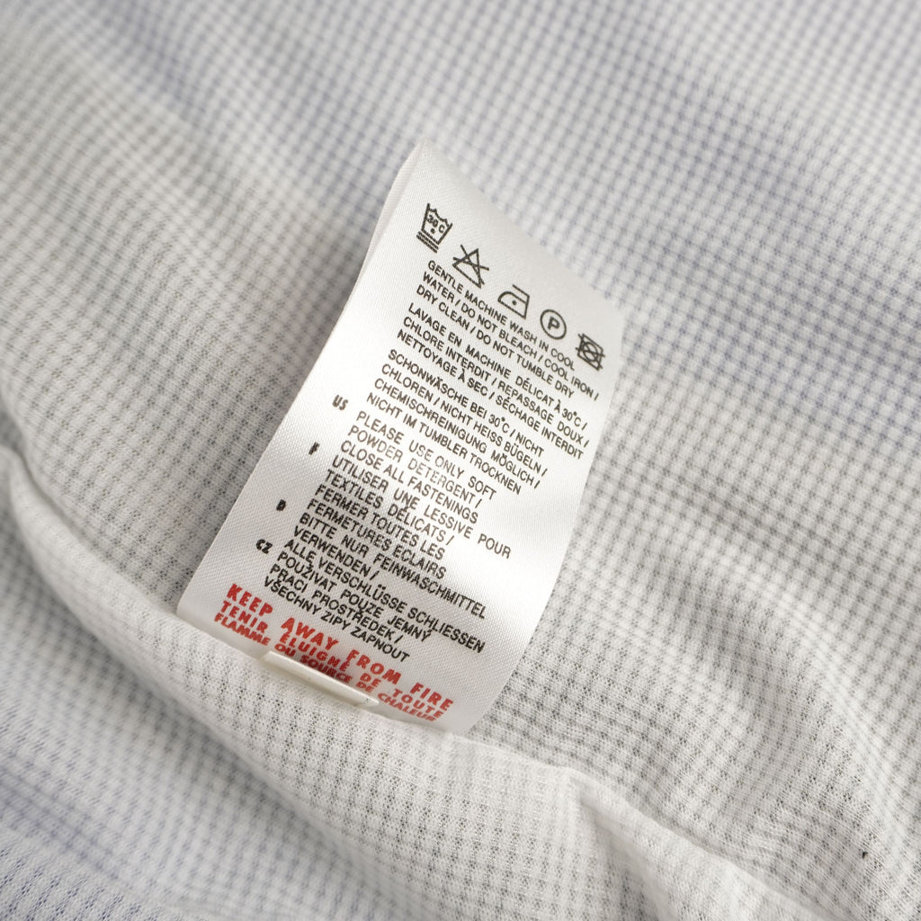 Dettaglio del retro dell'etichetta interna con le specifiche di composizione del tessuto in nylon.
