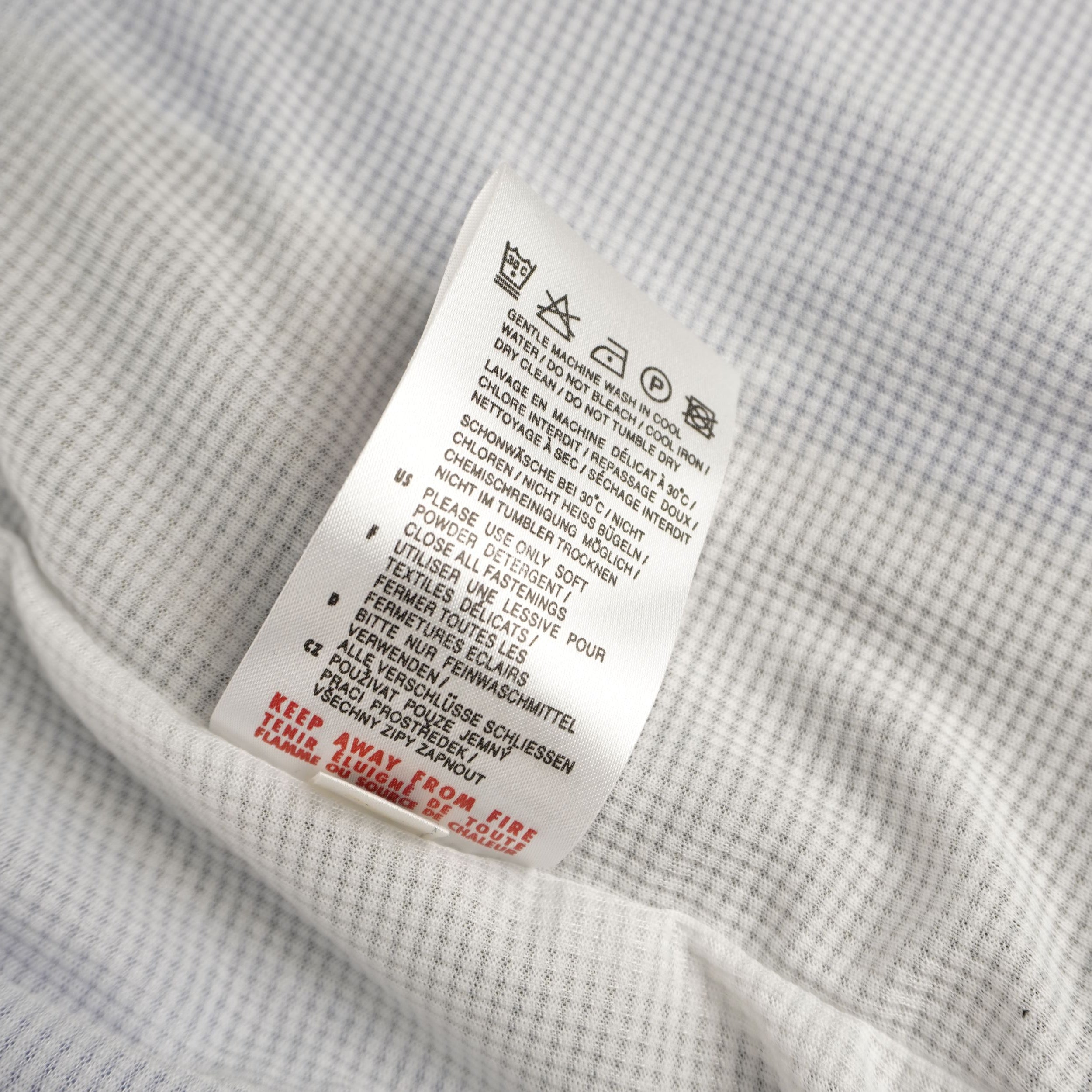 Dettaglio del retro dell'etichetta interna con le specifiche di composizione del tessuto in nylon.