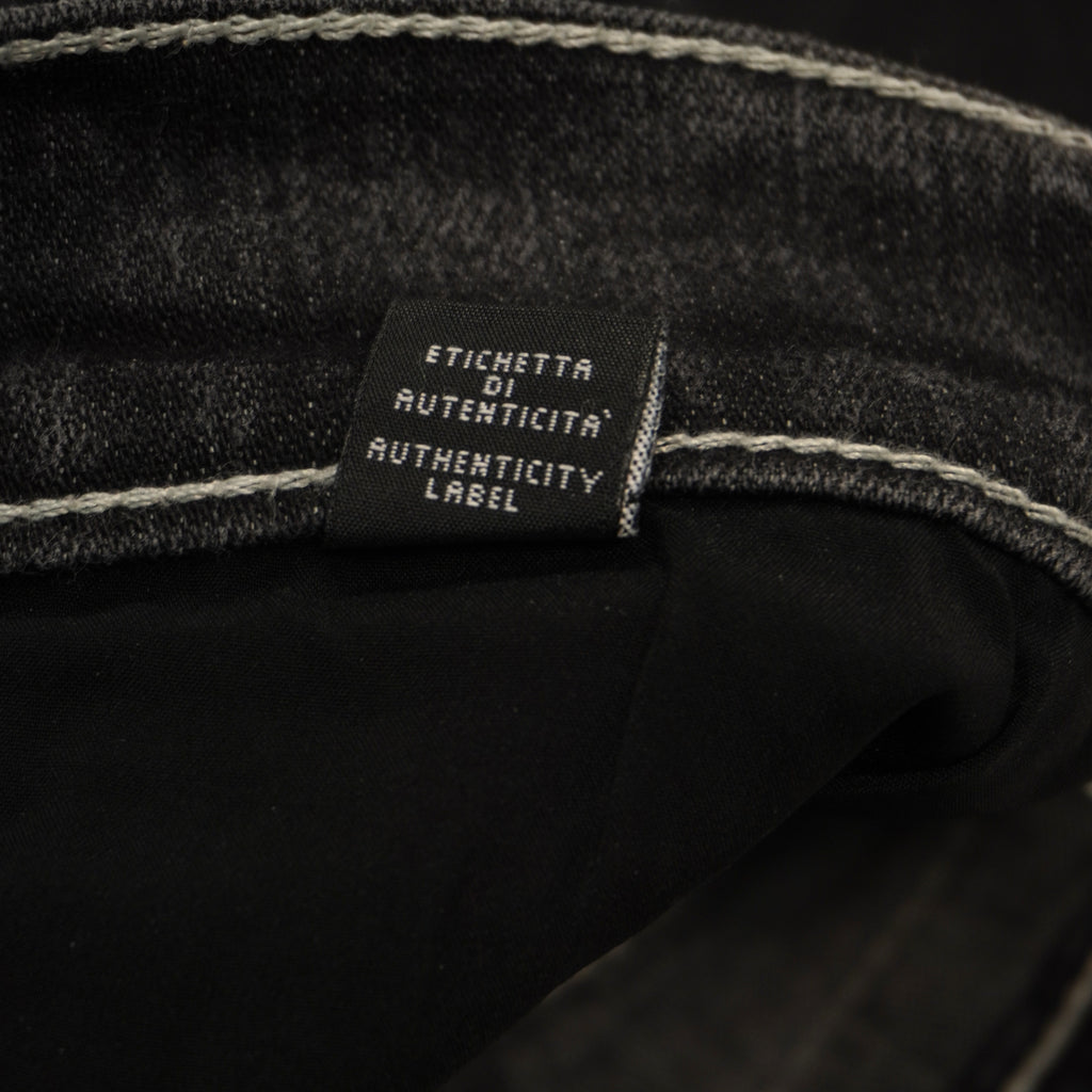 Macro dell'etichetta tecnica interna in tessuto scuro che attesta la composizione dei materiali e la produzione Made in Italy.