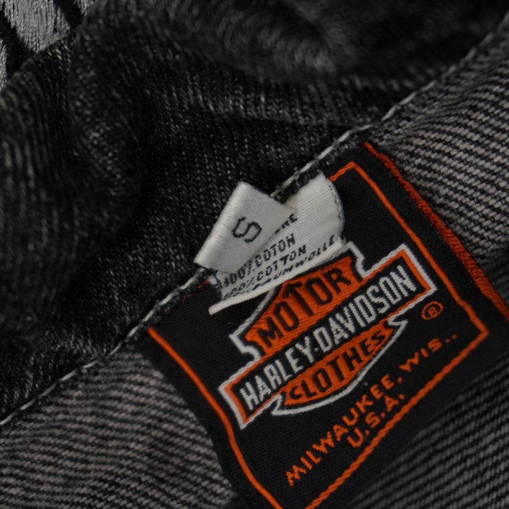 Dettaglio del retro del tag superiore che attesta la composizione tessile in 100% cotone pesante della giacca denim d'archivio.