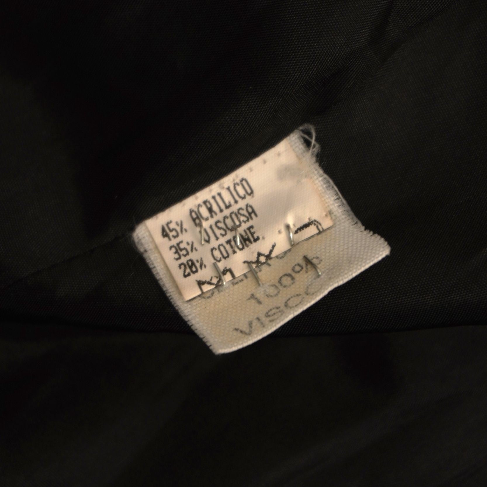 Etichetta interna cartacea con le percentuali di acrilico, viscosa e cotone e le istruzioni di lavaggio della giacca vintage Pavarotti.