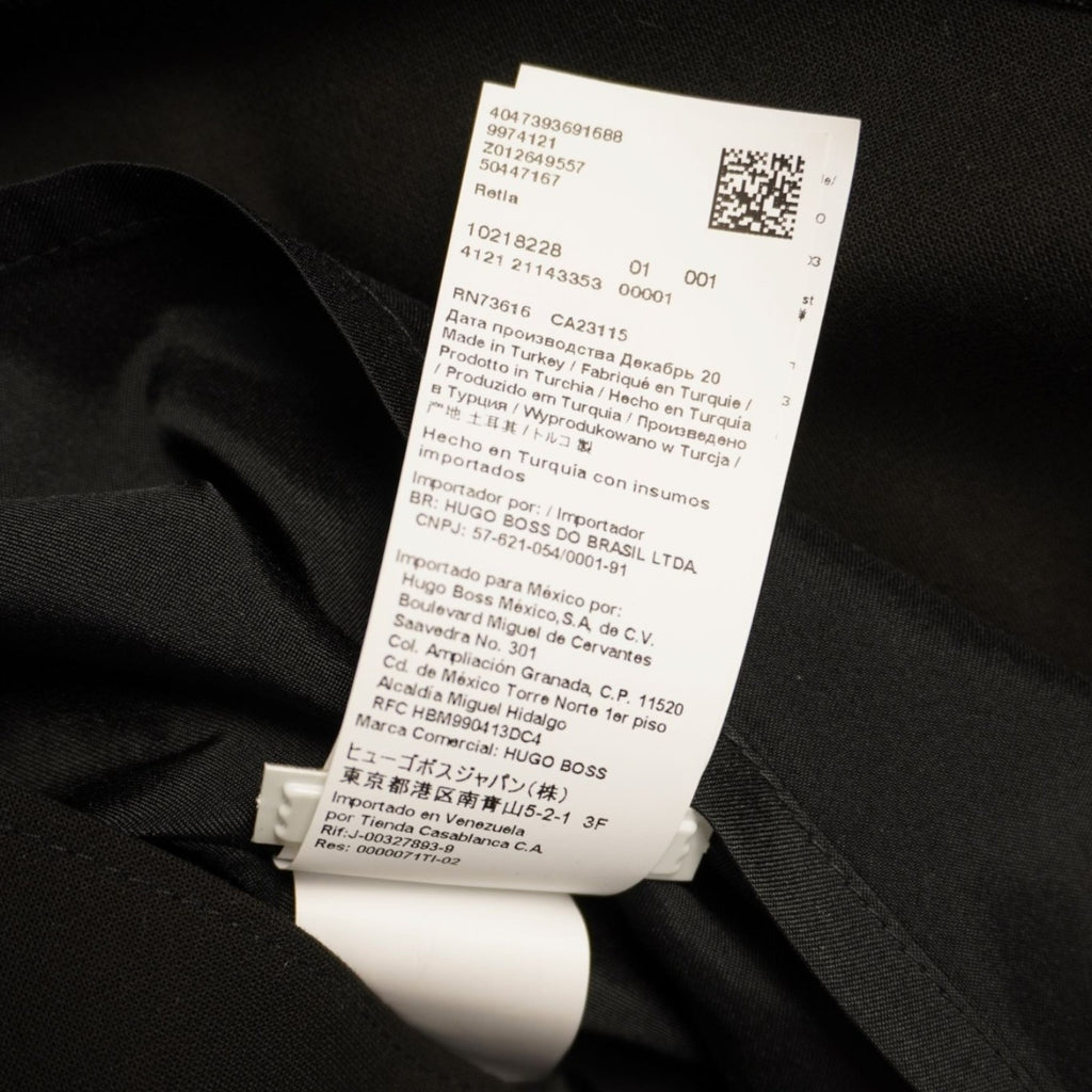 Primo piano dell'etichetta interna con la composizione dei materiali e il codice QR del brand HUGO.