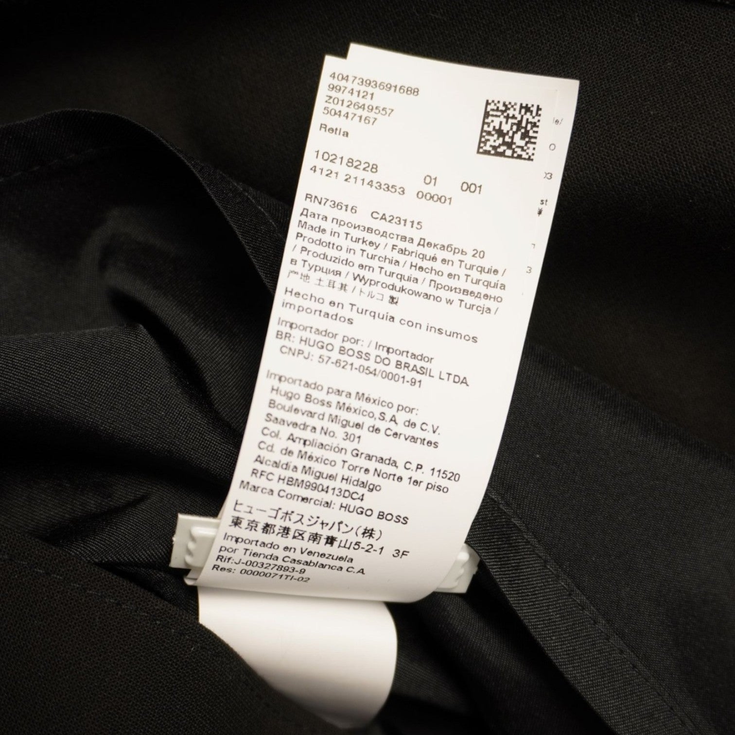 Primo piano dell'etichetta interna con la composizione dei materiali e il codice QR del brand HUGO.