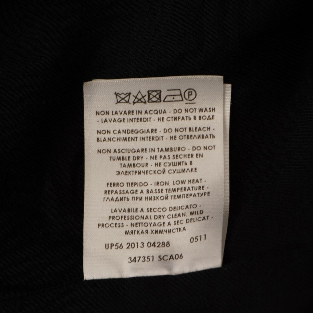 Etichetta interna in tessuto bianco che riporta la composizione dei materiali in più lingue e l'indicazione Made in Hungary.