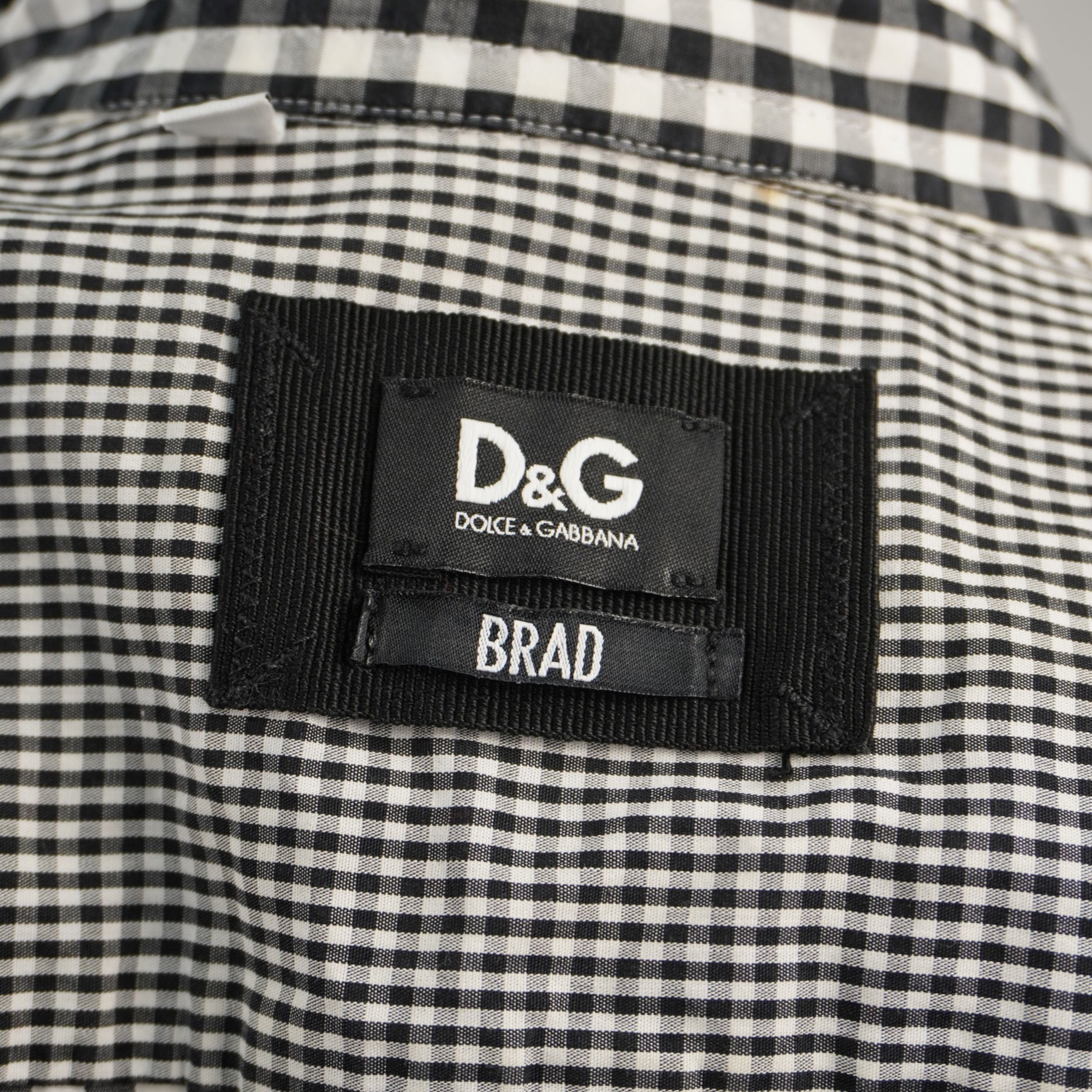 Primo piano dell'etichetta nera ricamata D&G Dolce & Gabbana con indicazione del modello Brad, cucita nel colletto.