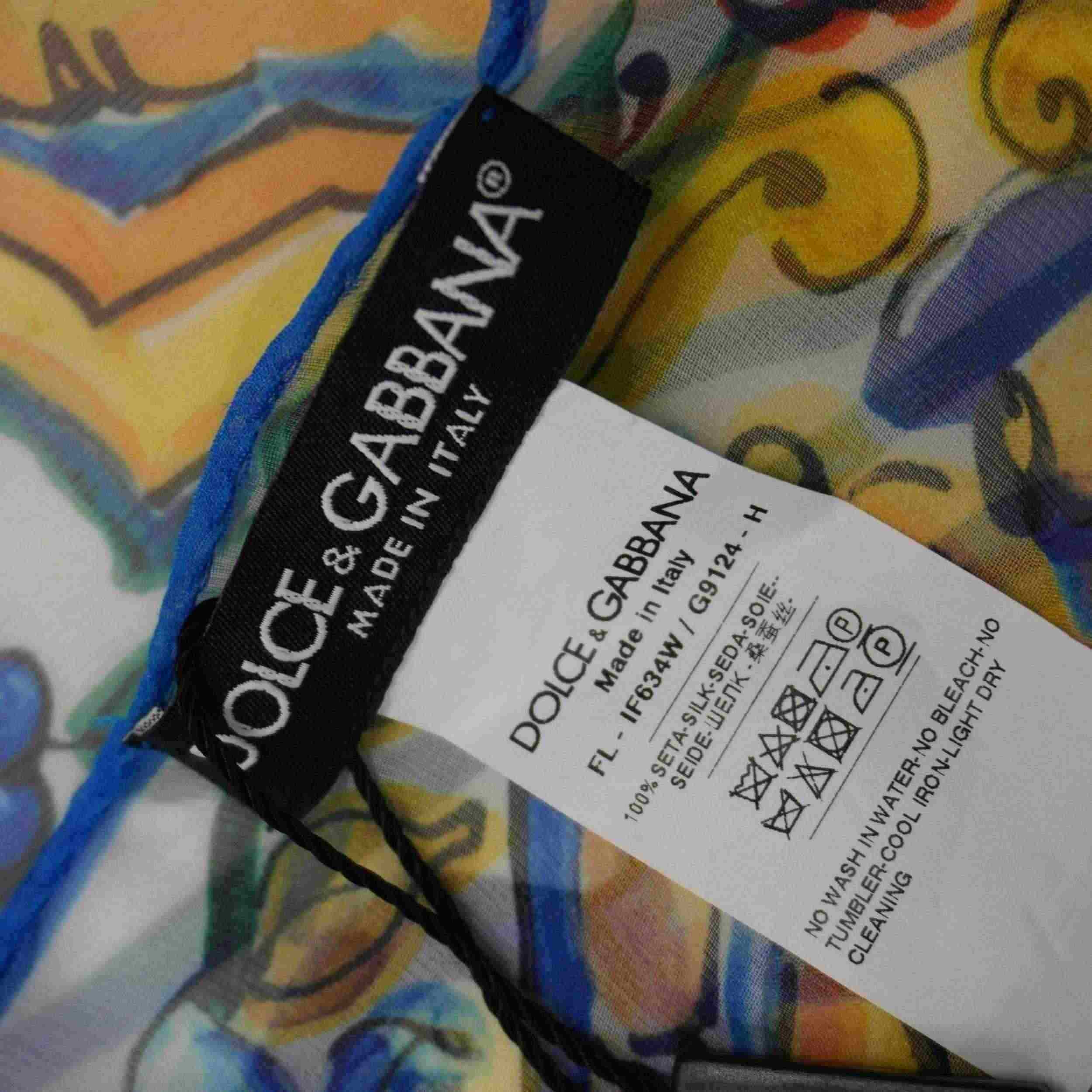 Dettaglio dell'etichetta nera tessuta Dolce & Gabbana "Made in Italy" e del cartellino tecnico con codici di autenticità.