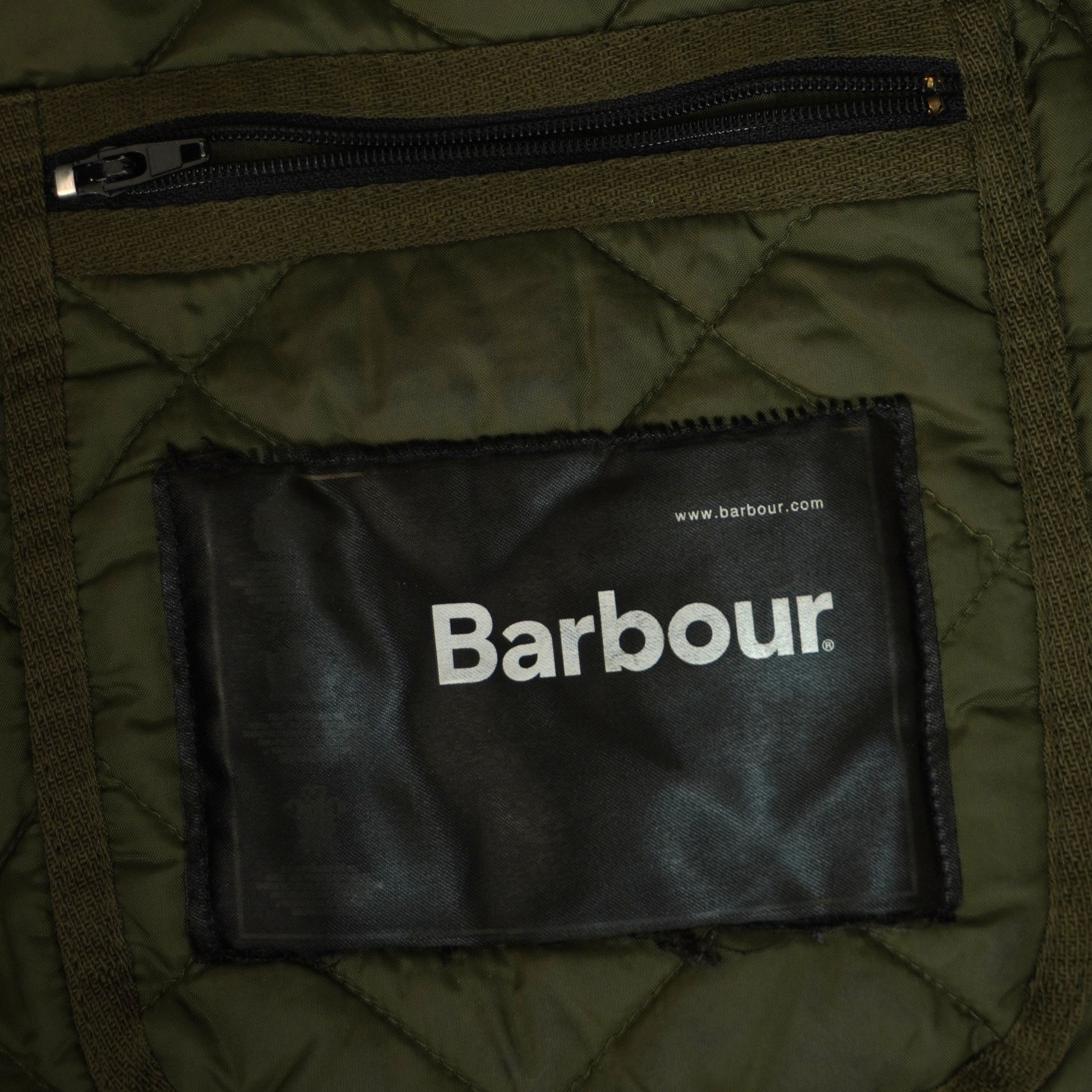  Dettaglio dell'etichetta principale nera cucita sulla tasca interna con cerniera della giacca Barbour taglia XXL.